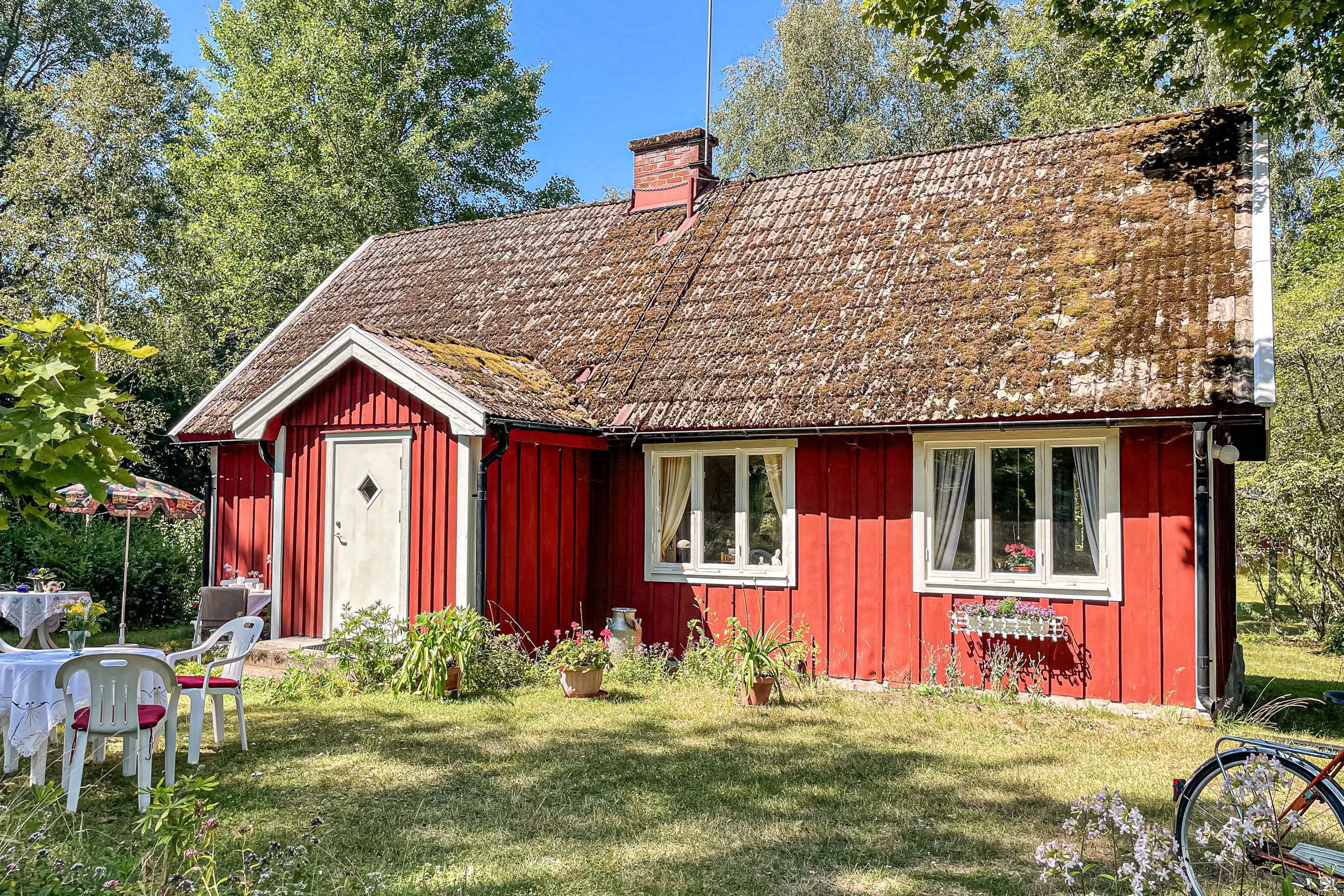 Det charmiga torpet smälter in i miljön med sin röda färg och vita detaljer