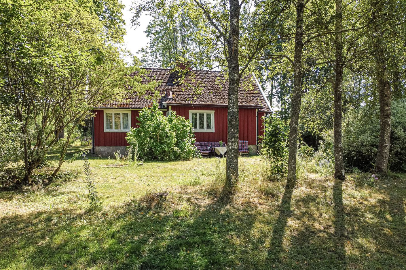 Det röda torpet ligger inbäddat i grönska
