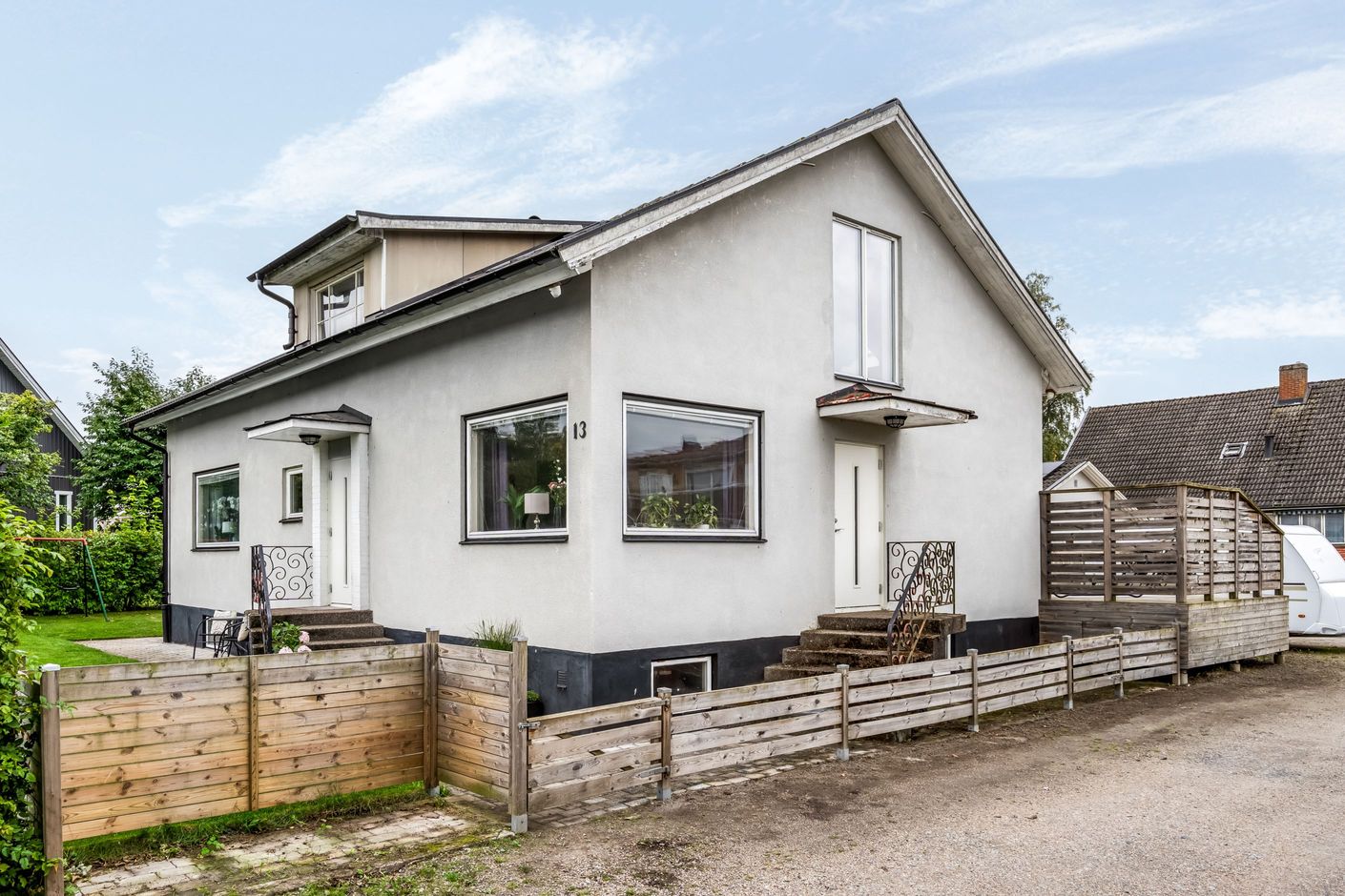 Villa med putsad fasad och välkomnande entrér