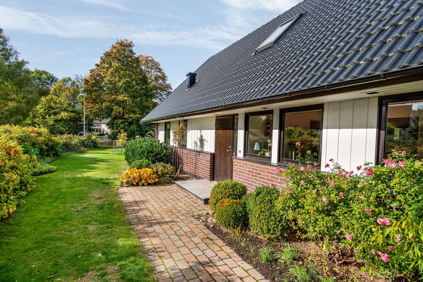 Trivsam entrésida med blomstrande inslag