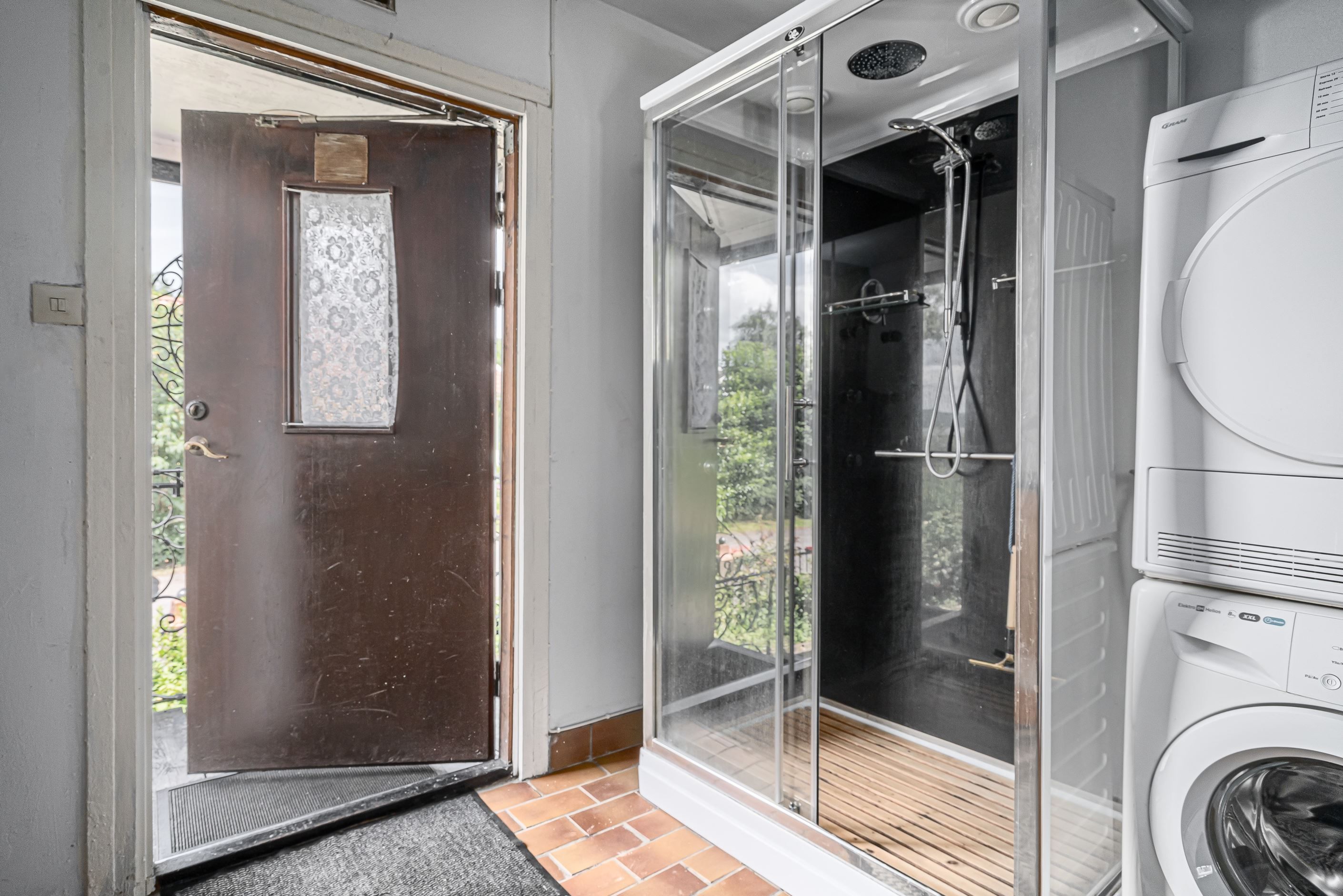 Hall med duschkabin och tvättmöjlighetr i annexet