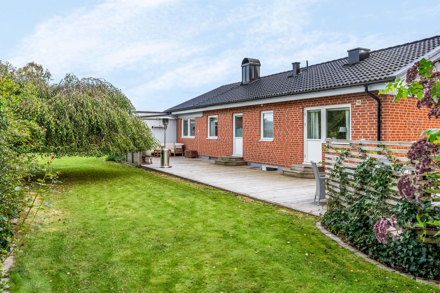 Stor insynsskyddad uteplat på baksidan av huset