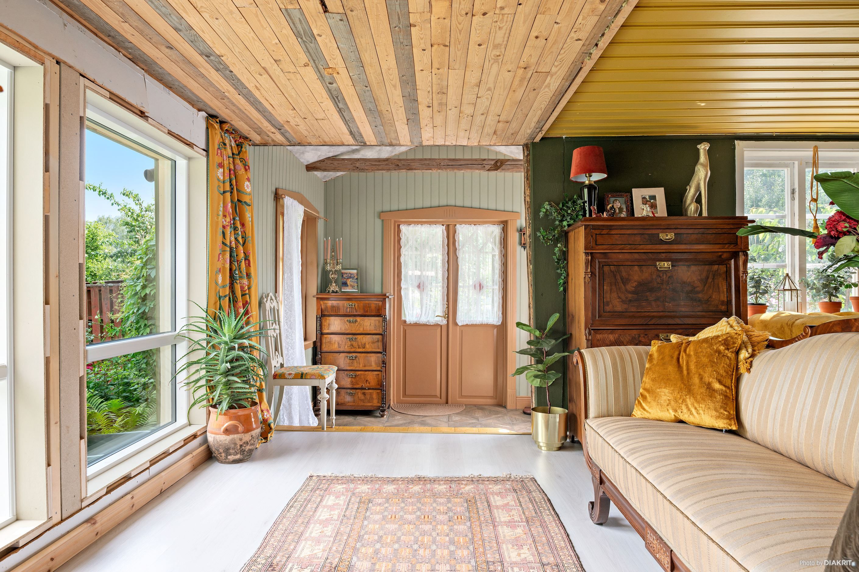 Vy mot entrén, stora fönster mot trädgården