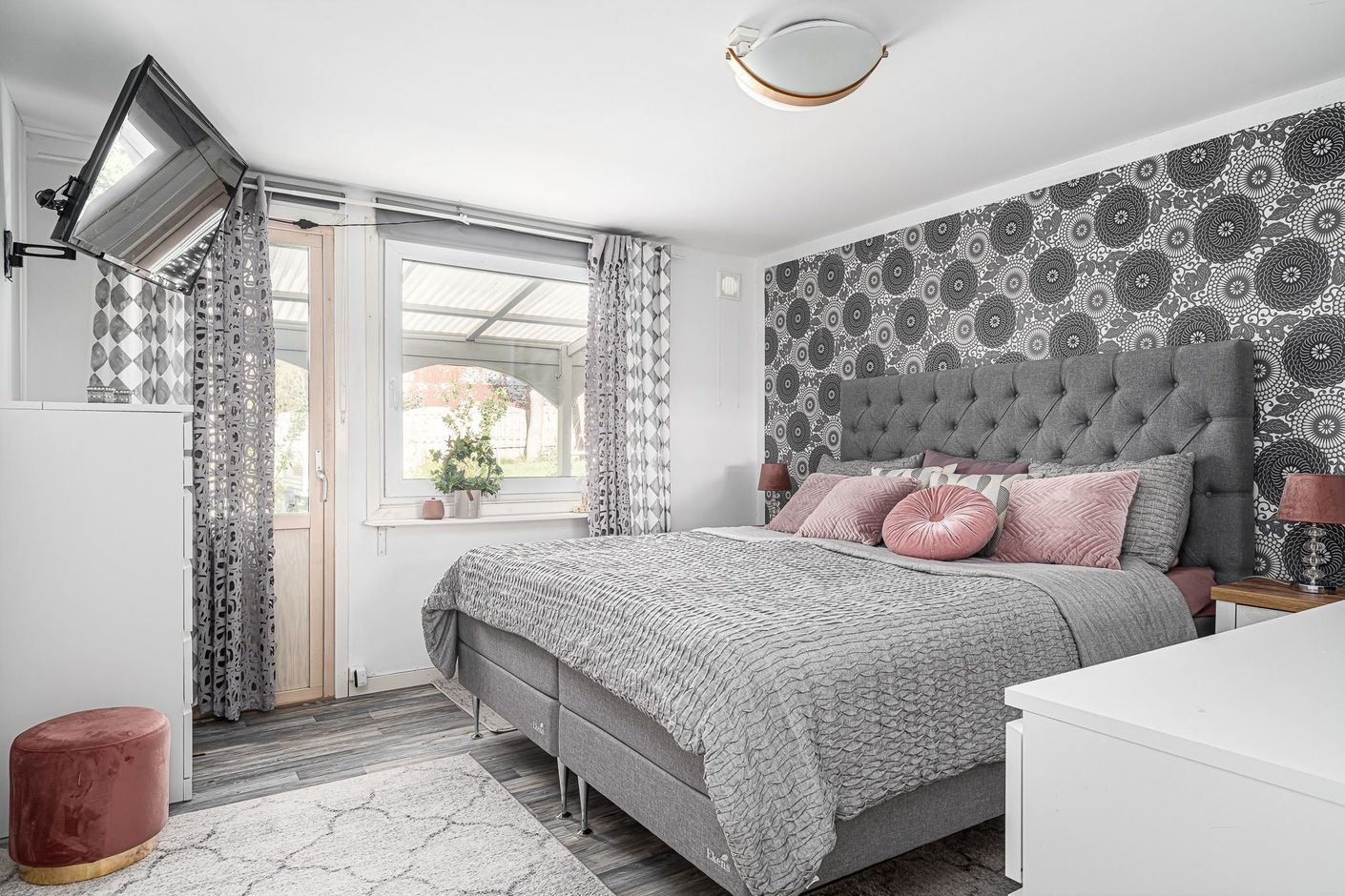 Master bedroom med dörr ut till uteplats och trädgård