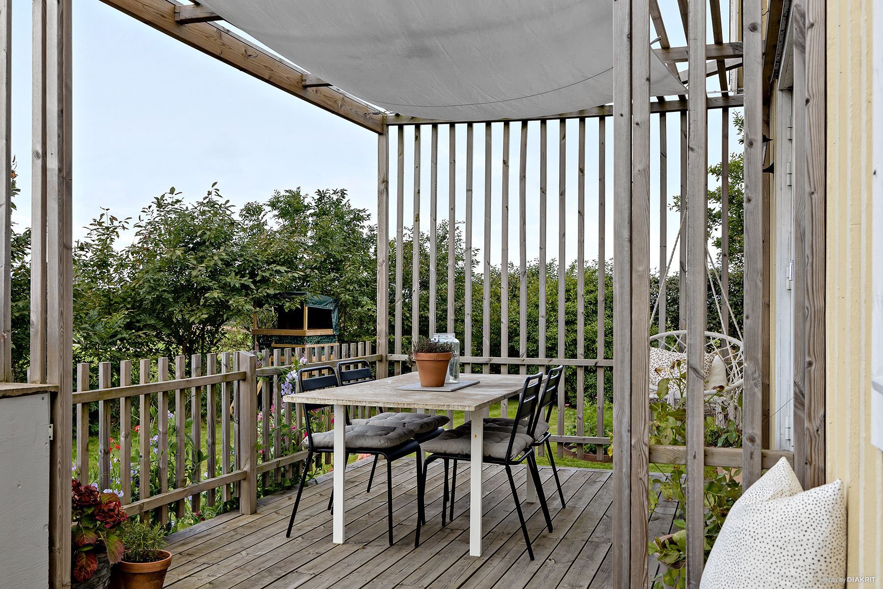 Supertrevlig uteplats under pergola vid vardagsrum/matplats