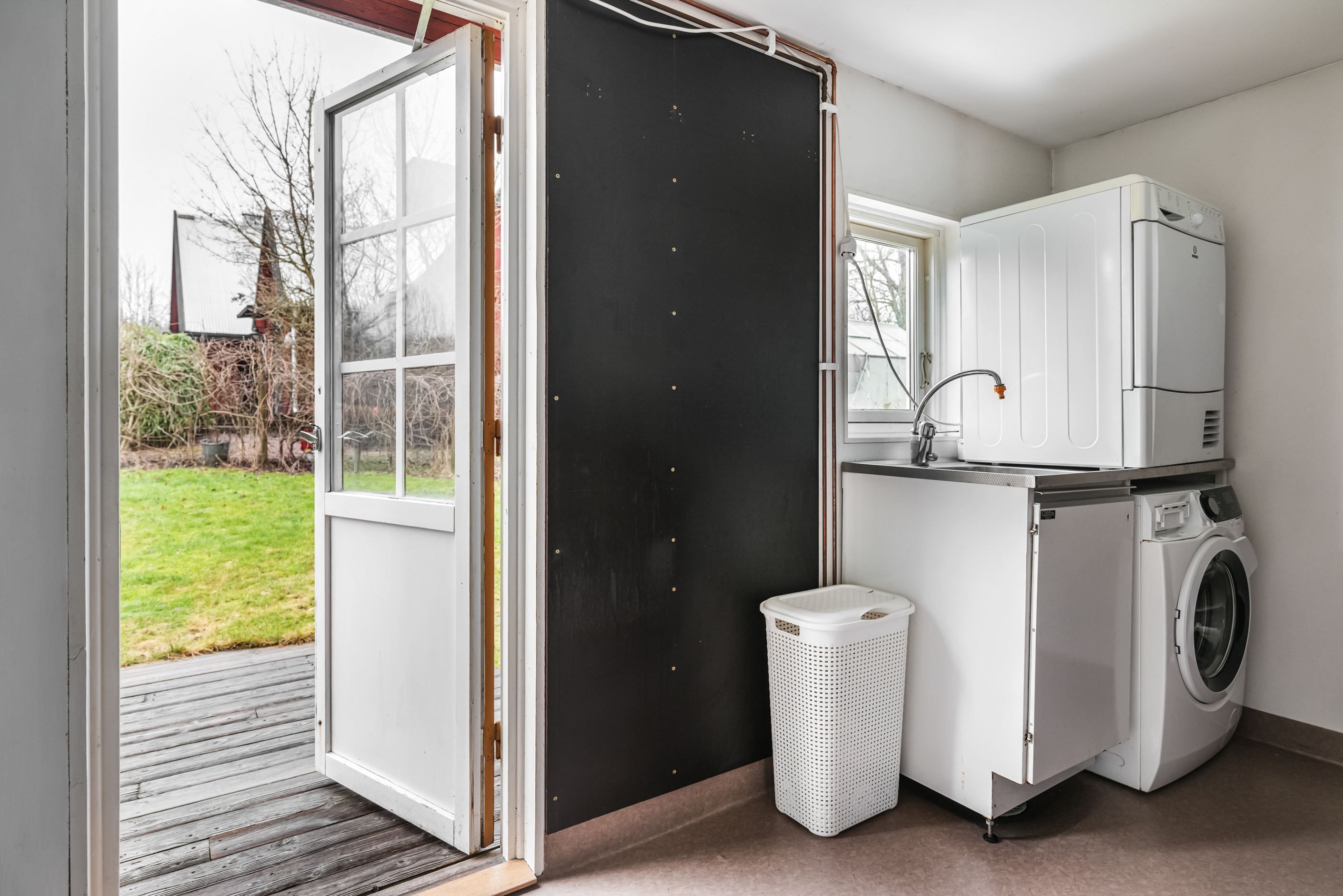 Tvättstuga med utgång till trädgården