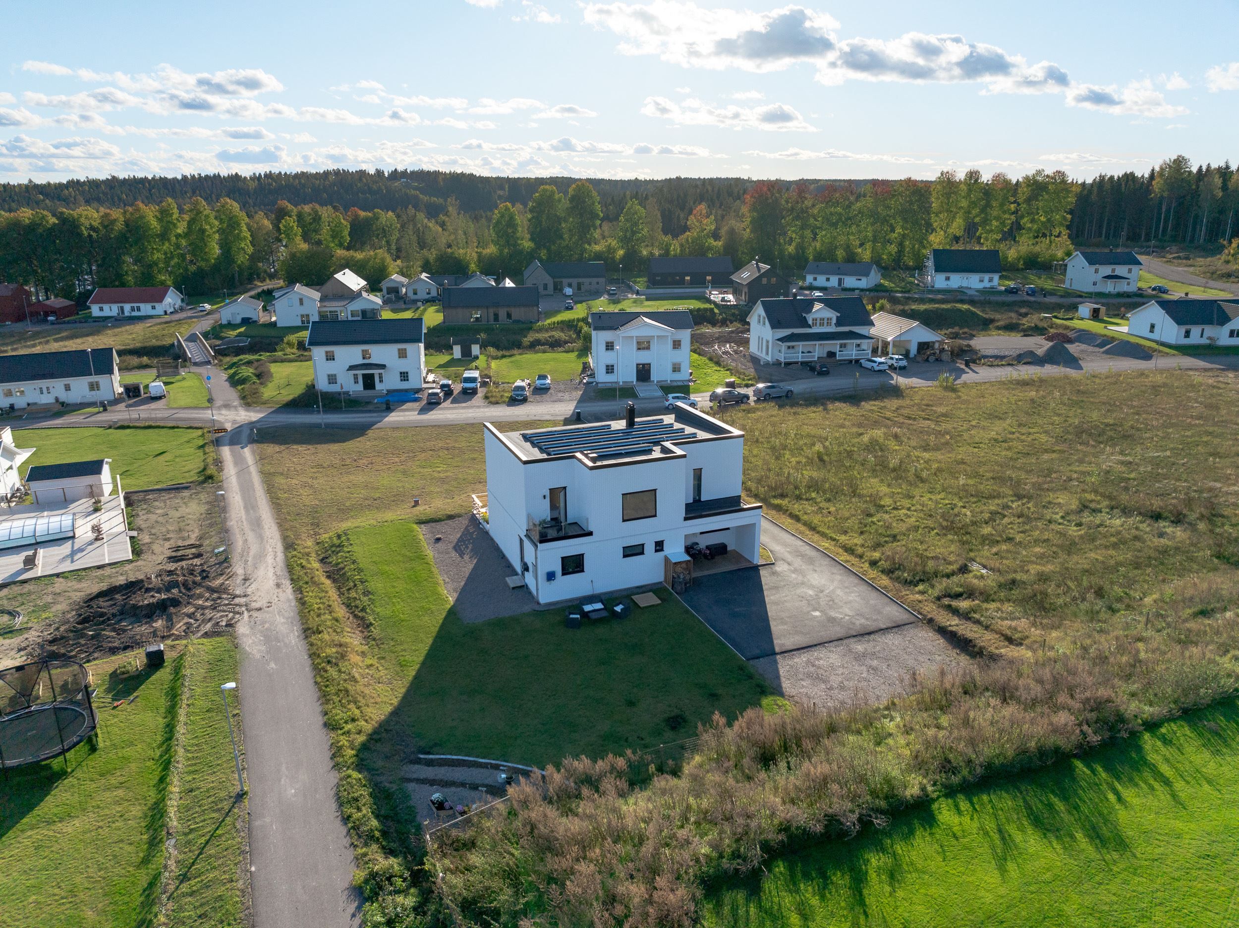 Entrésida med bilparkering