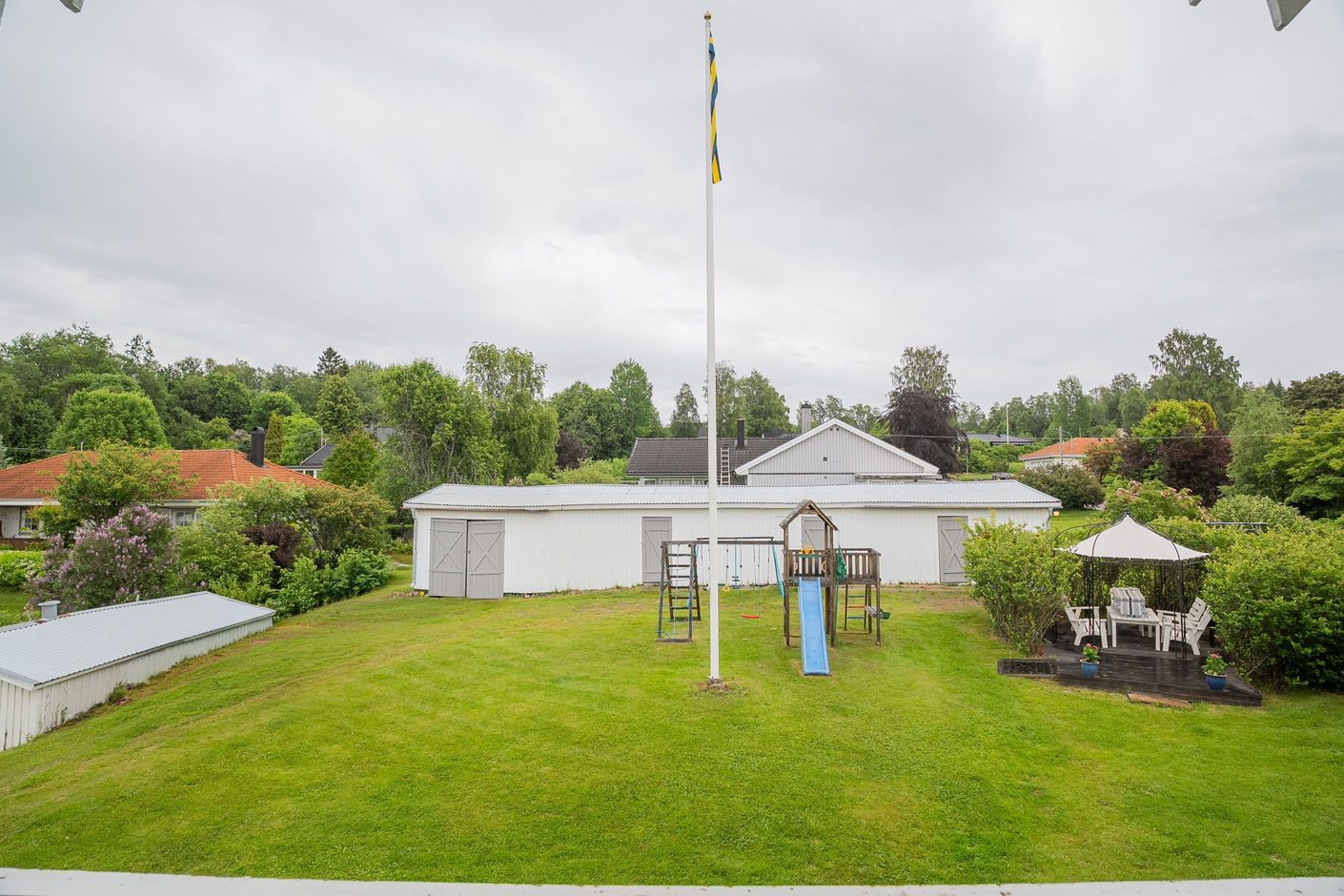 Förrådslängan med lekplats och uteplats