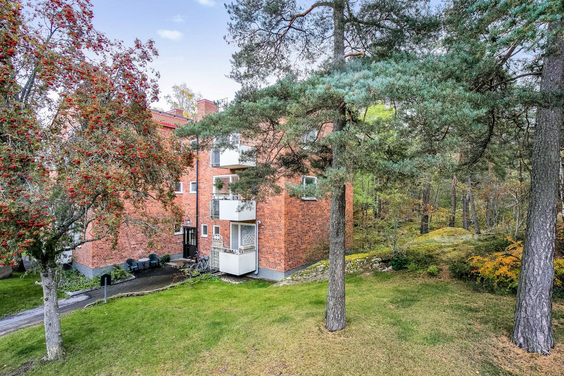 Huset inbäddad i grönska med allmänning intill