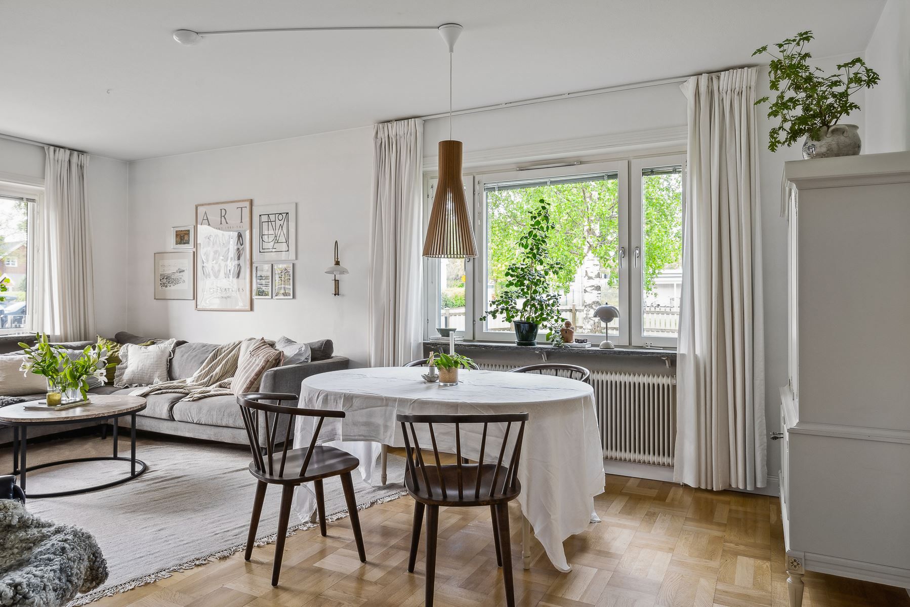 Vardagsrum med salongsdel och dekorativ öppen spis