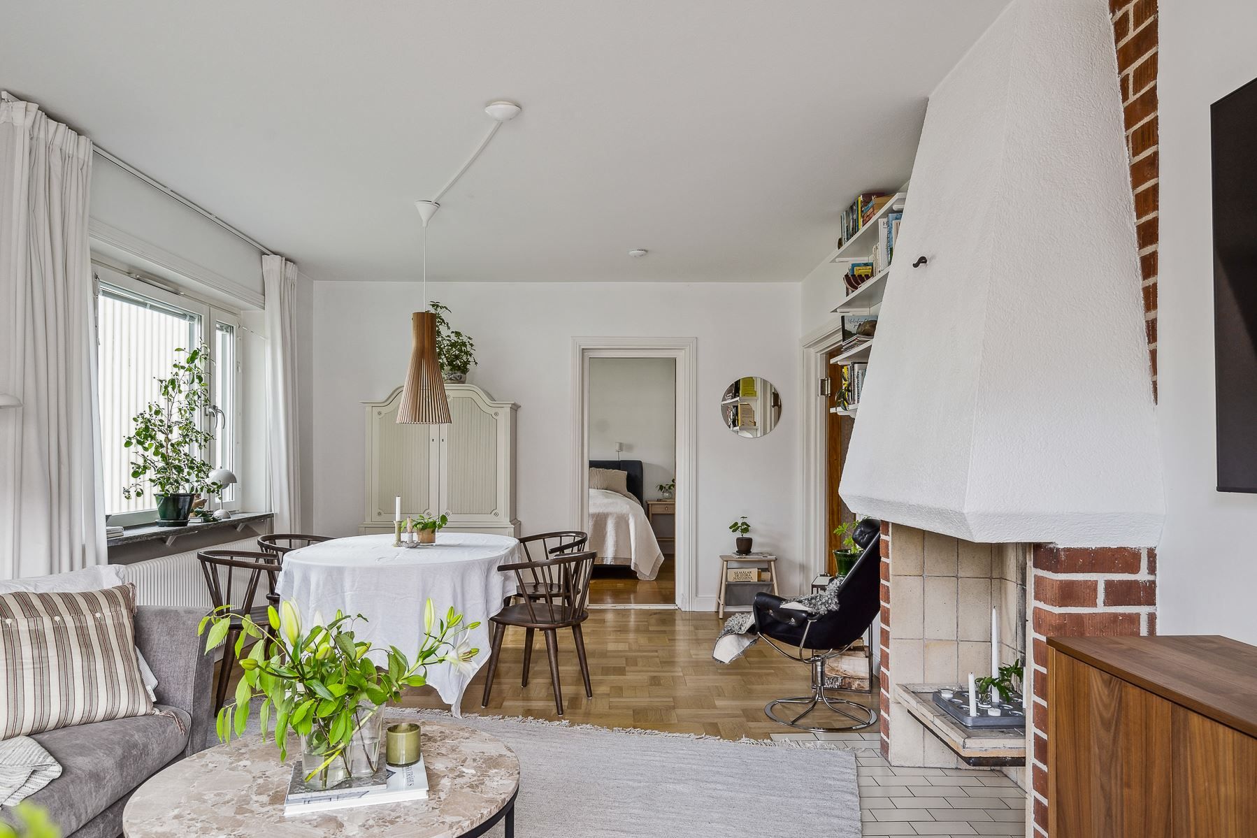 Vardagsrum med salongsdel och dekorativ öppen spis