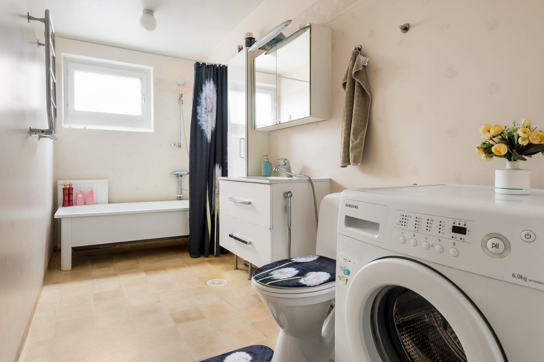 Stort badrum med badkar och tvättmaskin