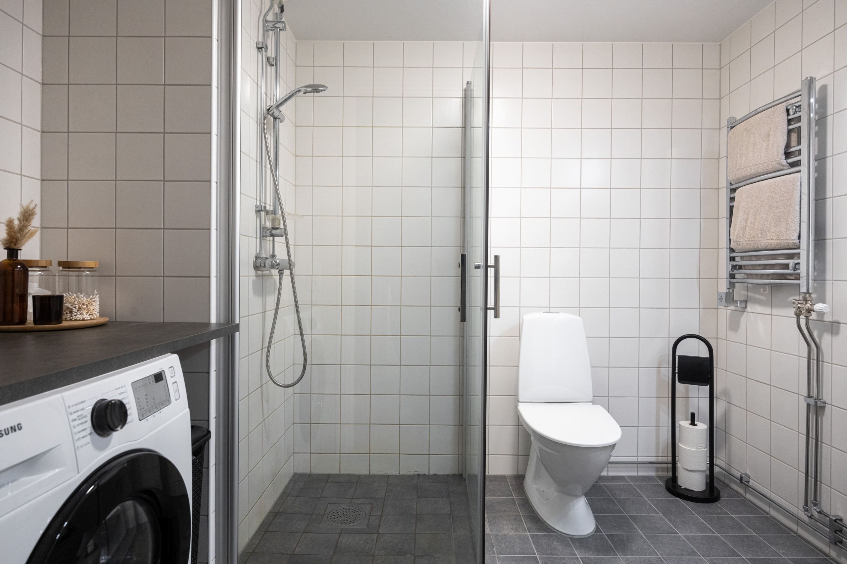 Helkaklat badrum med separat tvättdel.