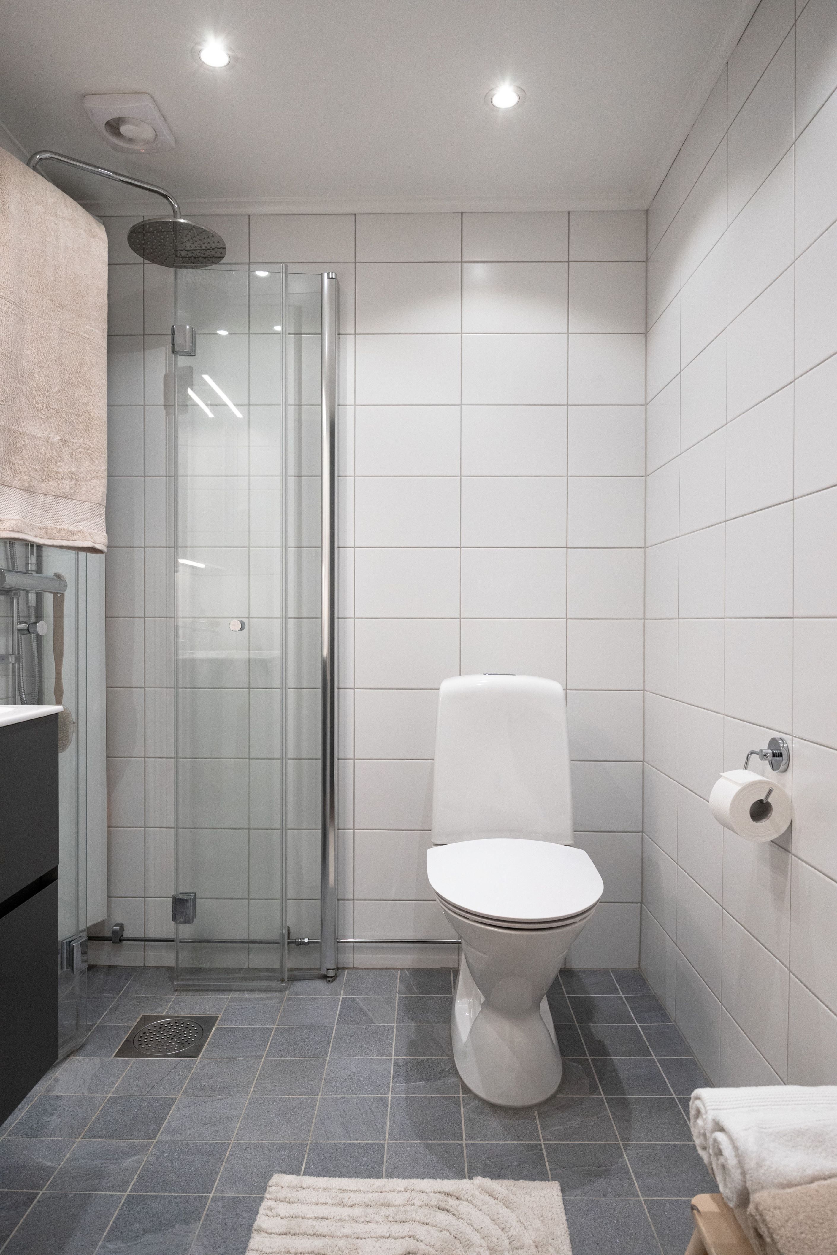 Badrum, dusch med glasvikdörrar.