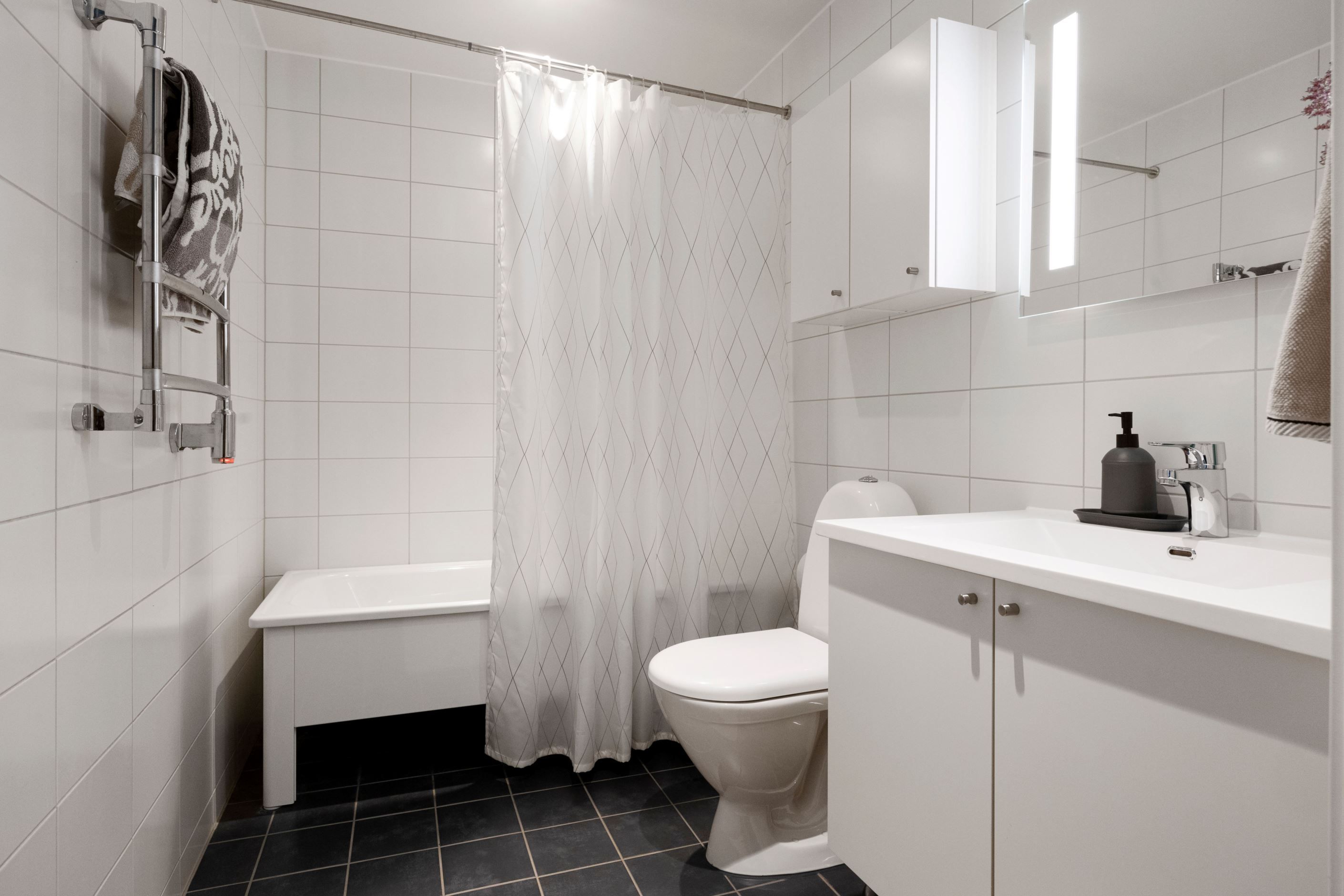 Bostadens andra badrum med badkar för avkopplande stunder.