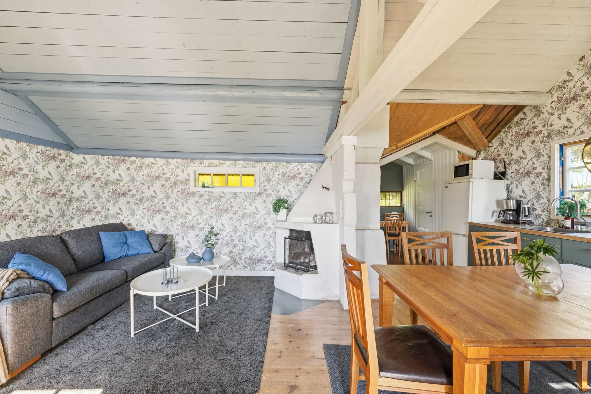 Allrum med kamin som leder vidare till köket.
