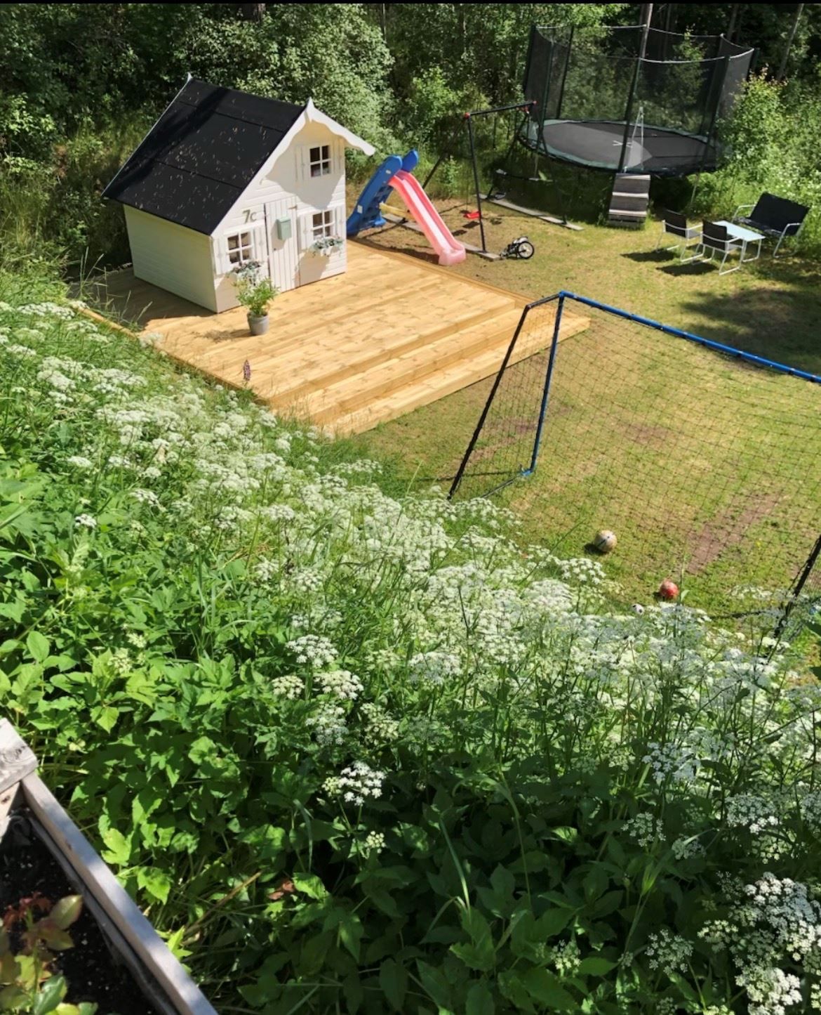 Lummig trädgård med skogen som närmsta granne. Här finns även en fin lekstuga för de små.