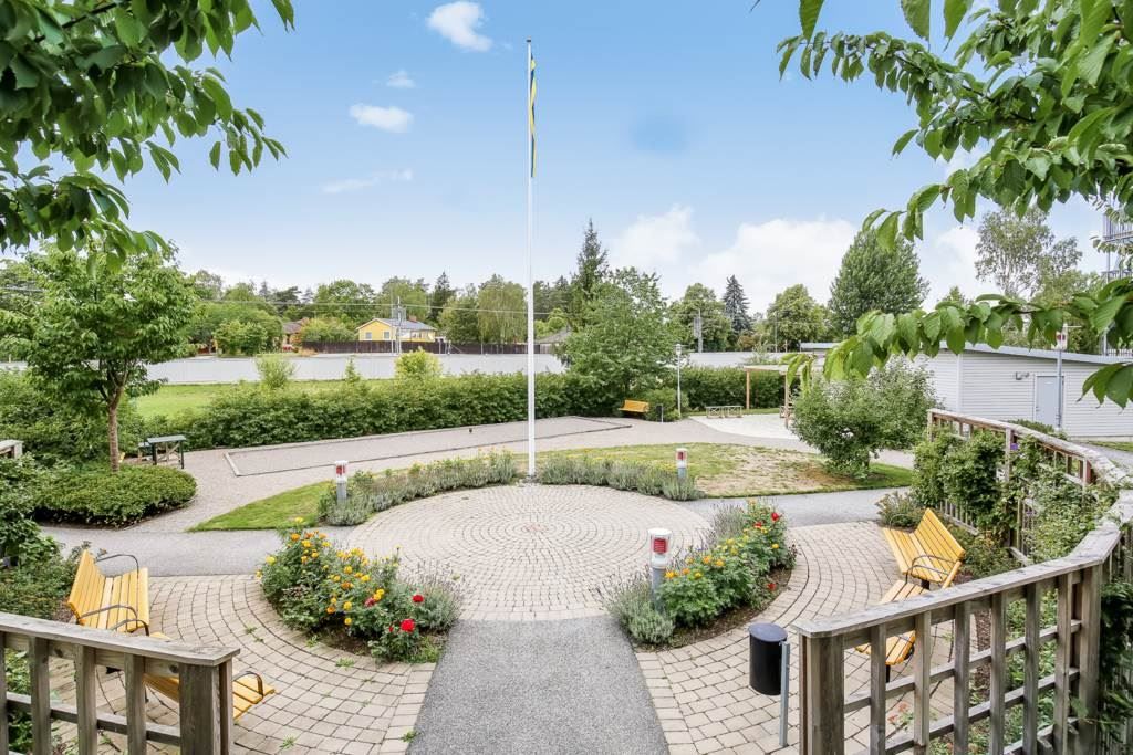 Den trevlig gården med planteringar och boulebana