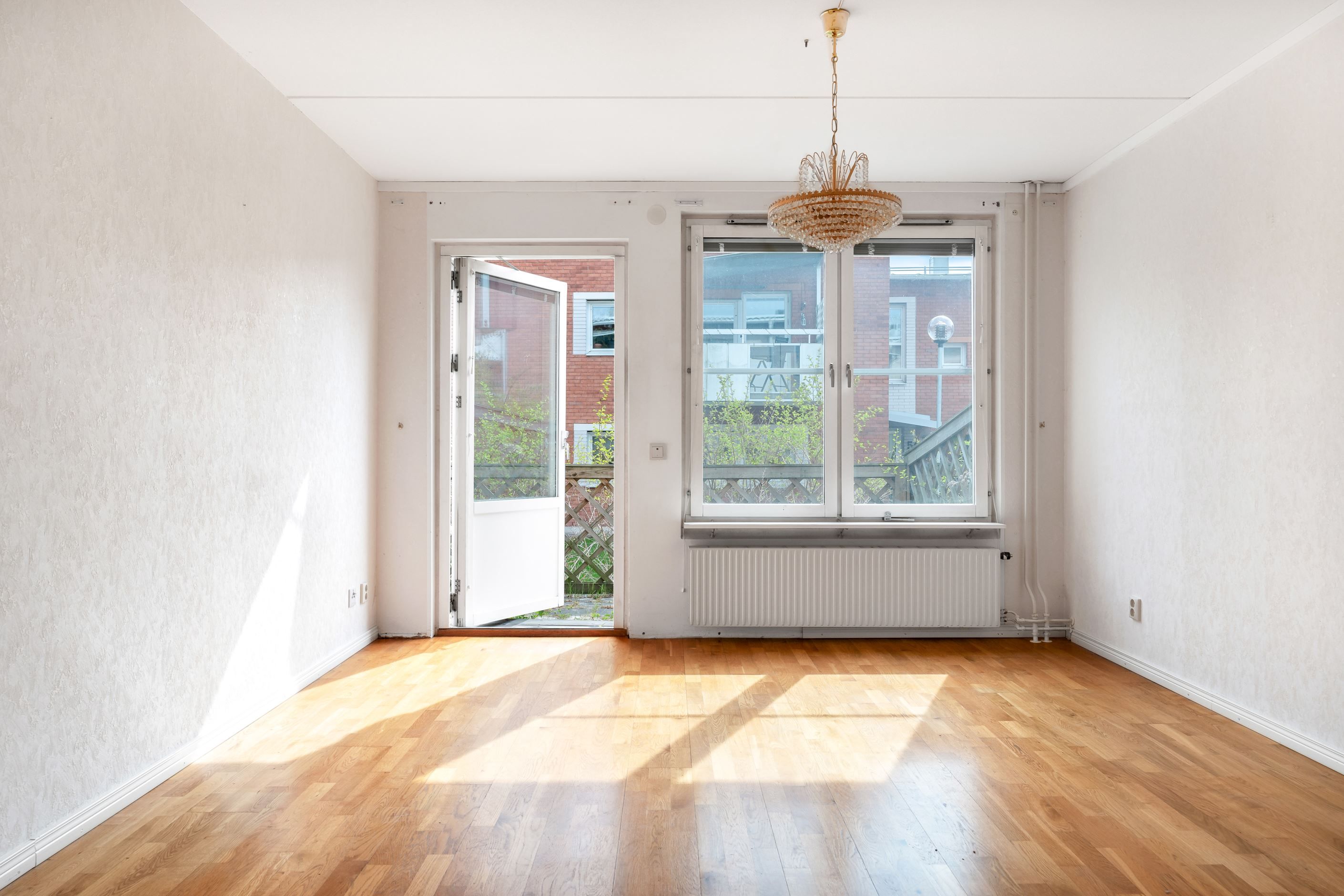 Ljust vardagsrum med utgång till bostadens lägenhet