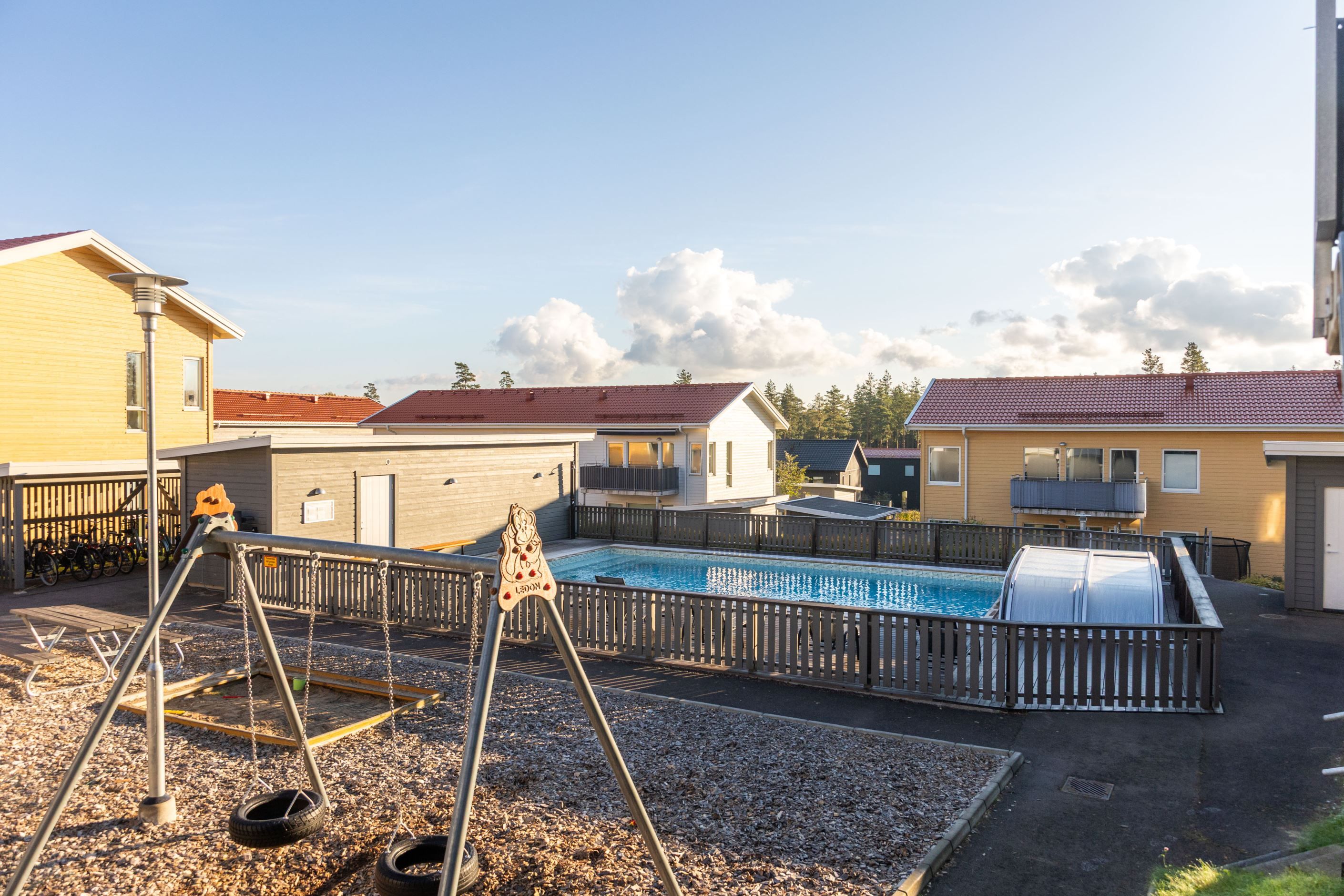 Gemensam lekplats och pool endast en trappa upp från lägenhetens uteplats!