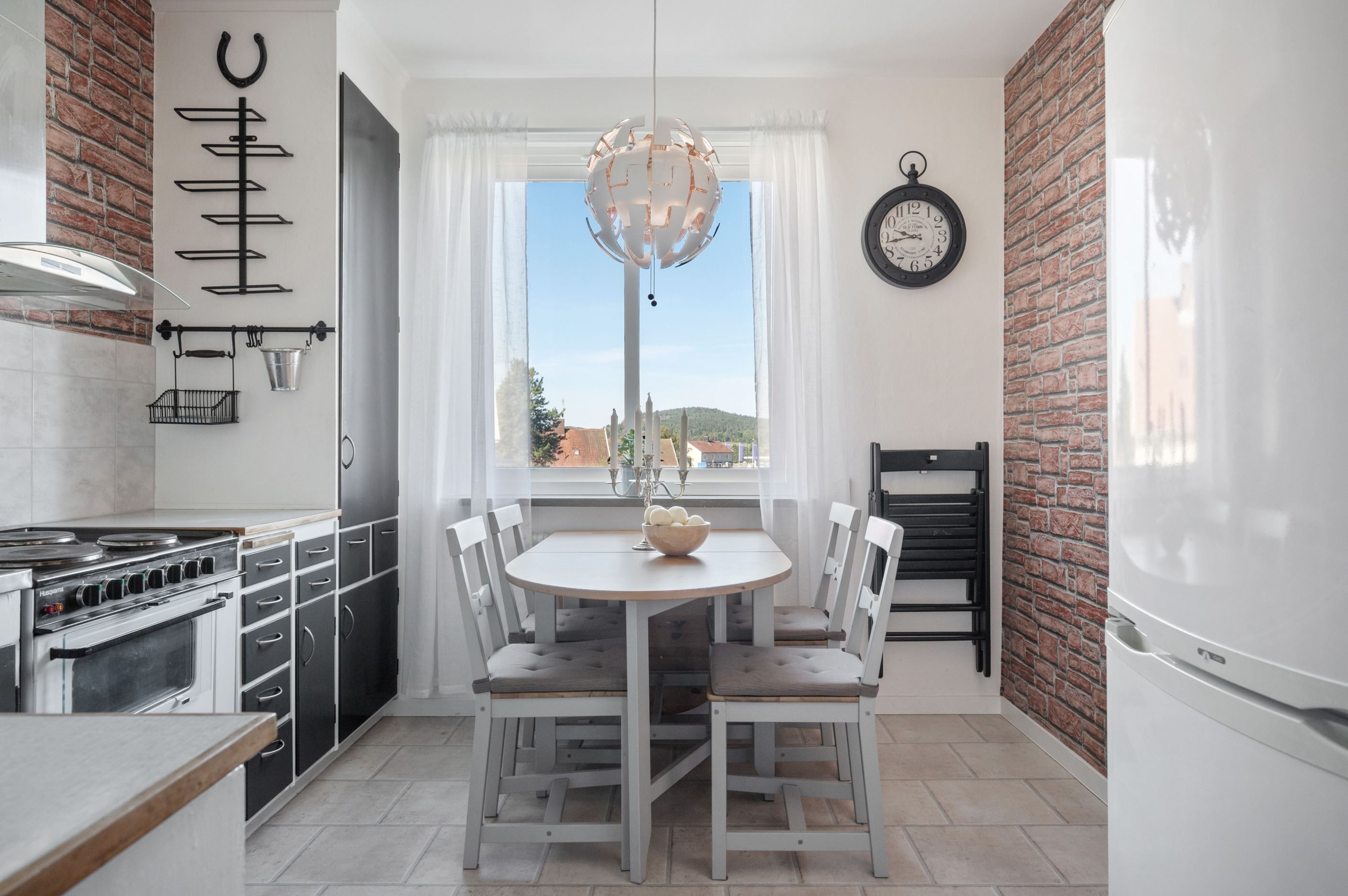 Hemtrevligt kök med plats för matbord.