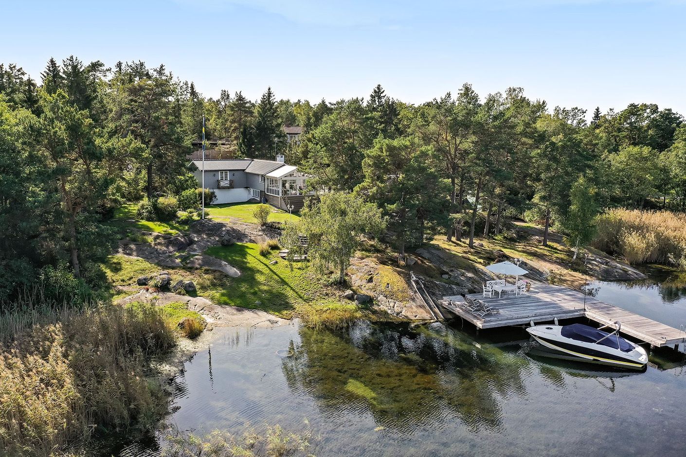 Klippor, liten strand och tillhörande brygganläggning