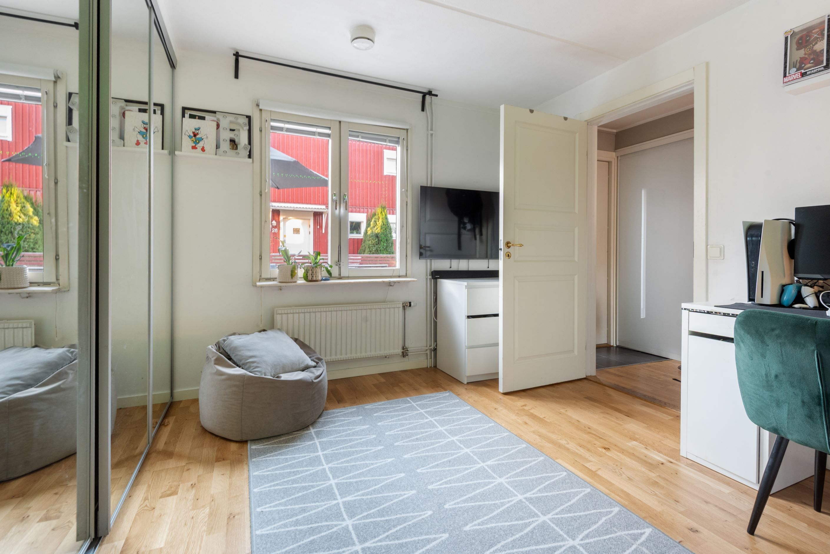 Sovrum med hel garderobsvägg bakom spegelskjutdörrar