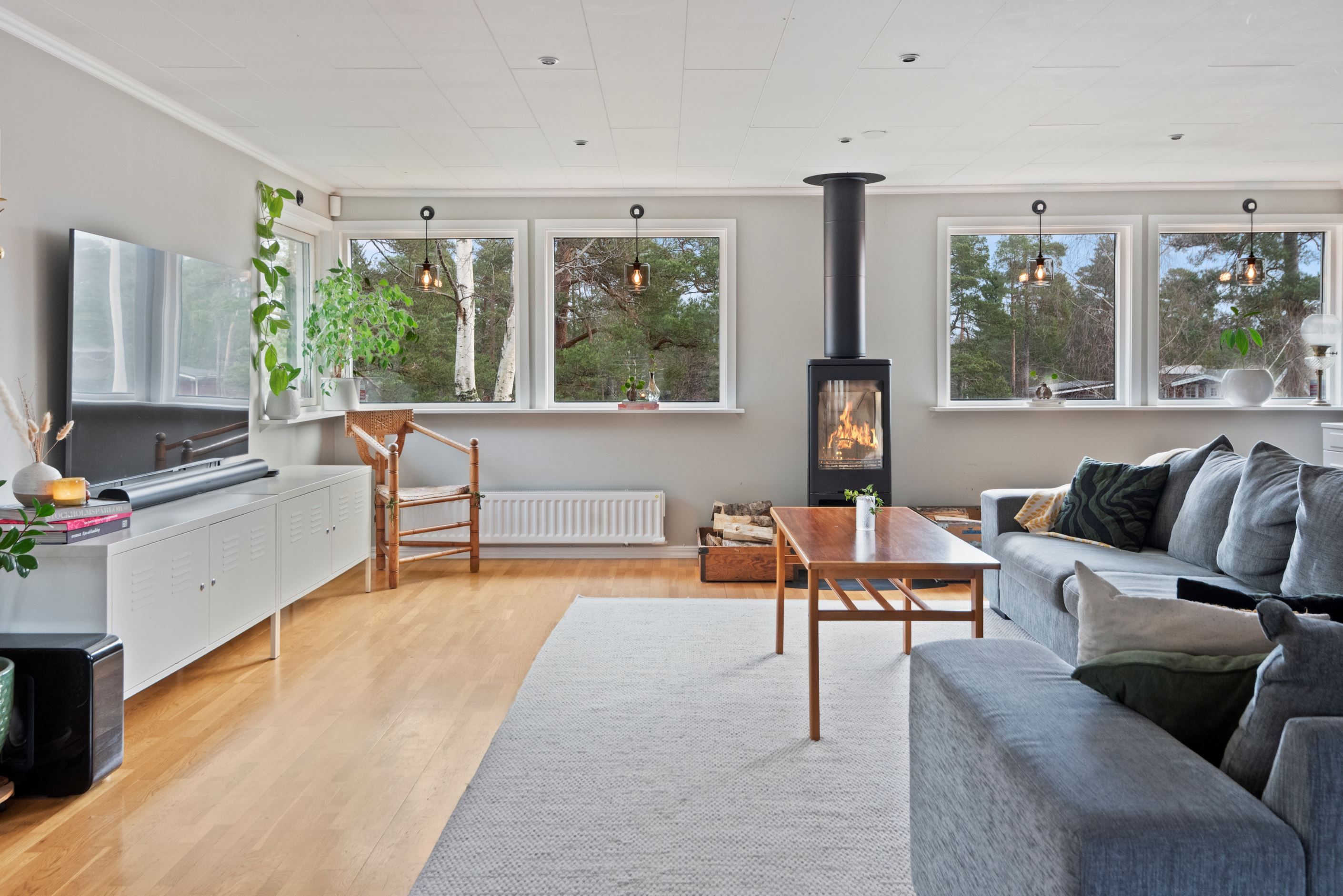Stort vardagsrum med braskamin och fönsterpartier i fin linje.