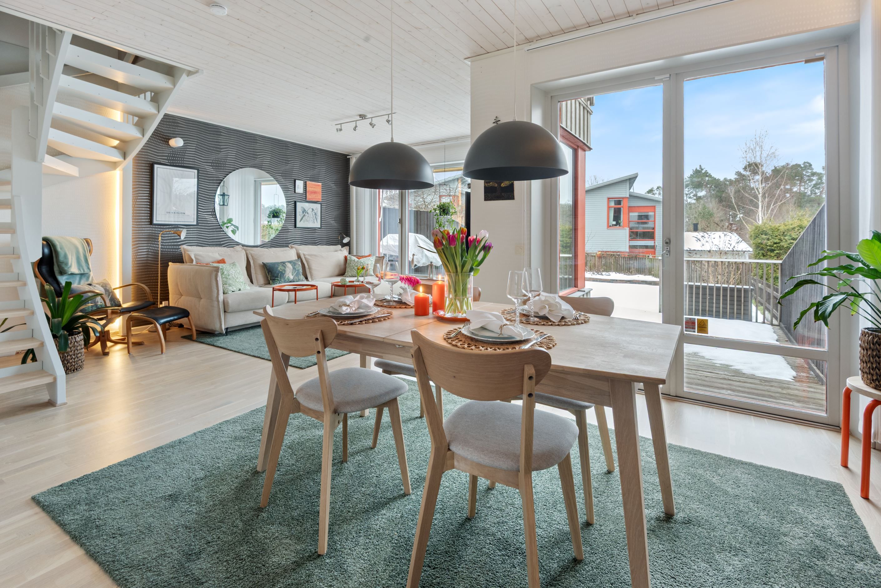 Öppen planlösning i vinkel med stora fönsterpartier.