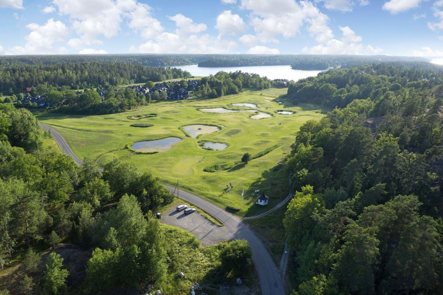 Golfbana mellan skog och hav.
