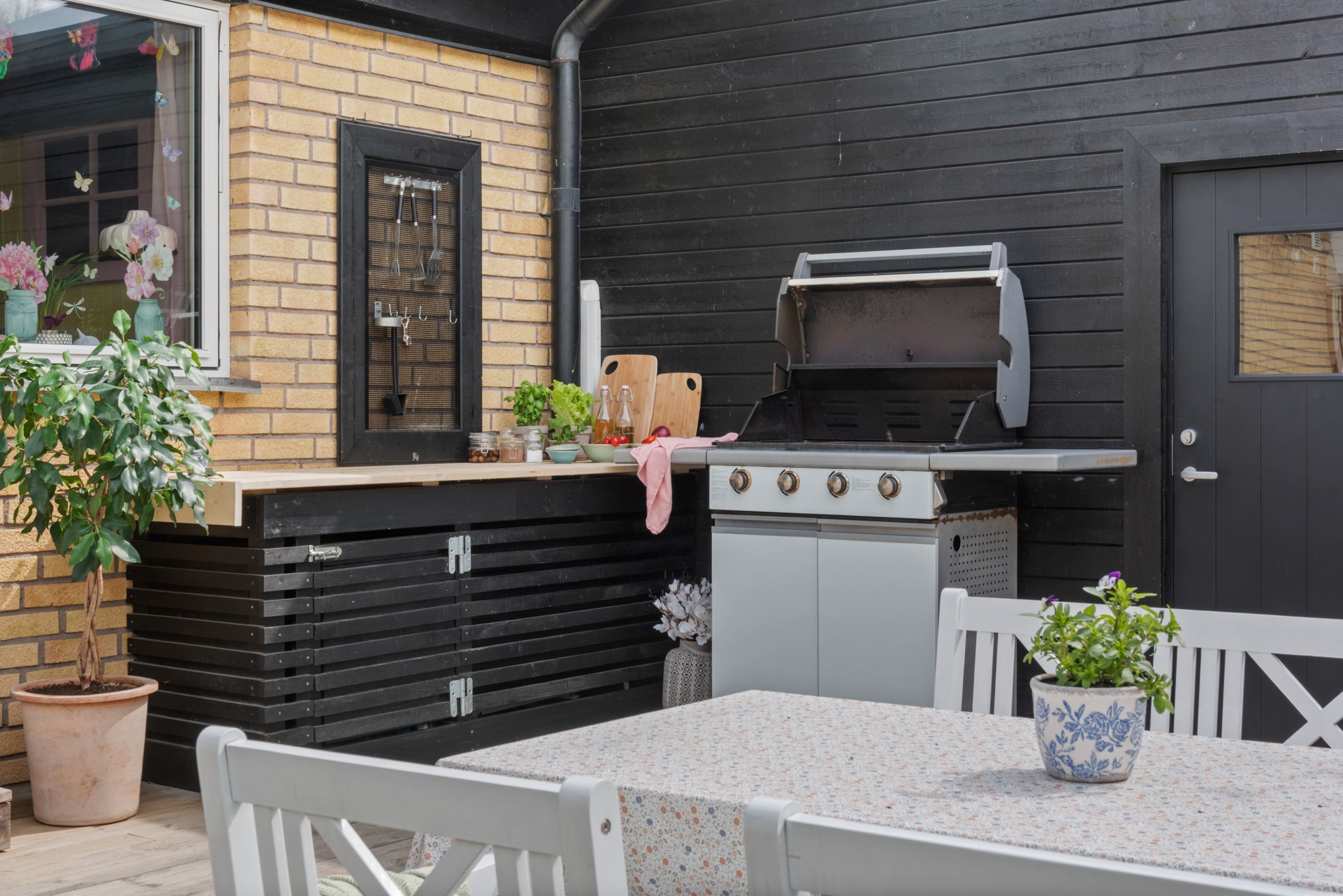 Grillhörna utanför ingång till förrådsutrymme och garage