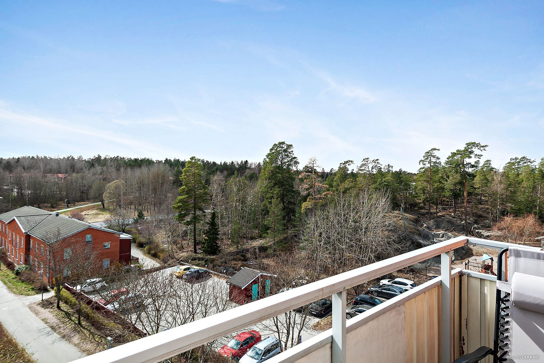 utsikt från balkong mot skog och äng