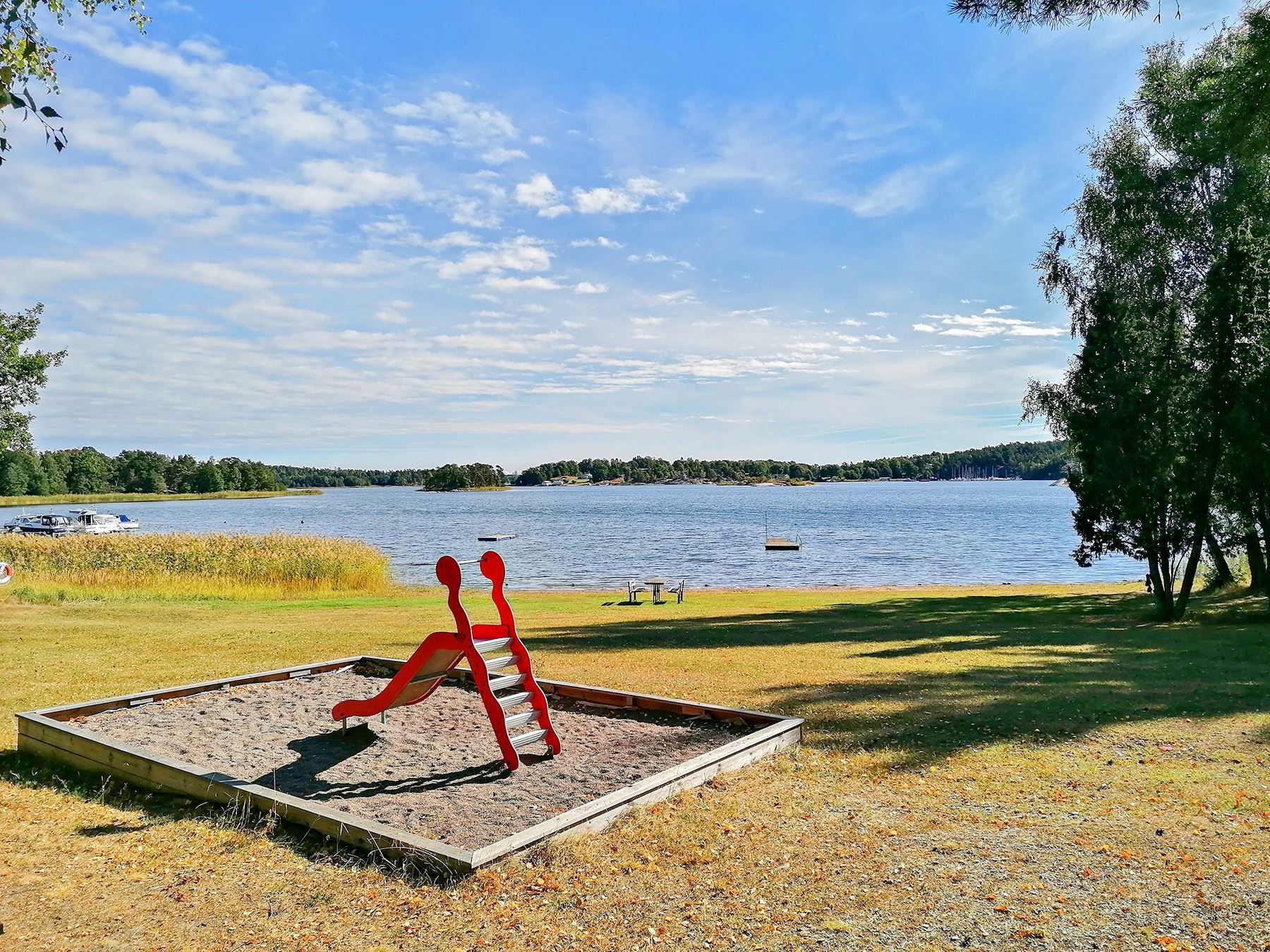 Lekplats och fina gräsmattor invid badstrand