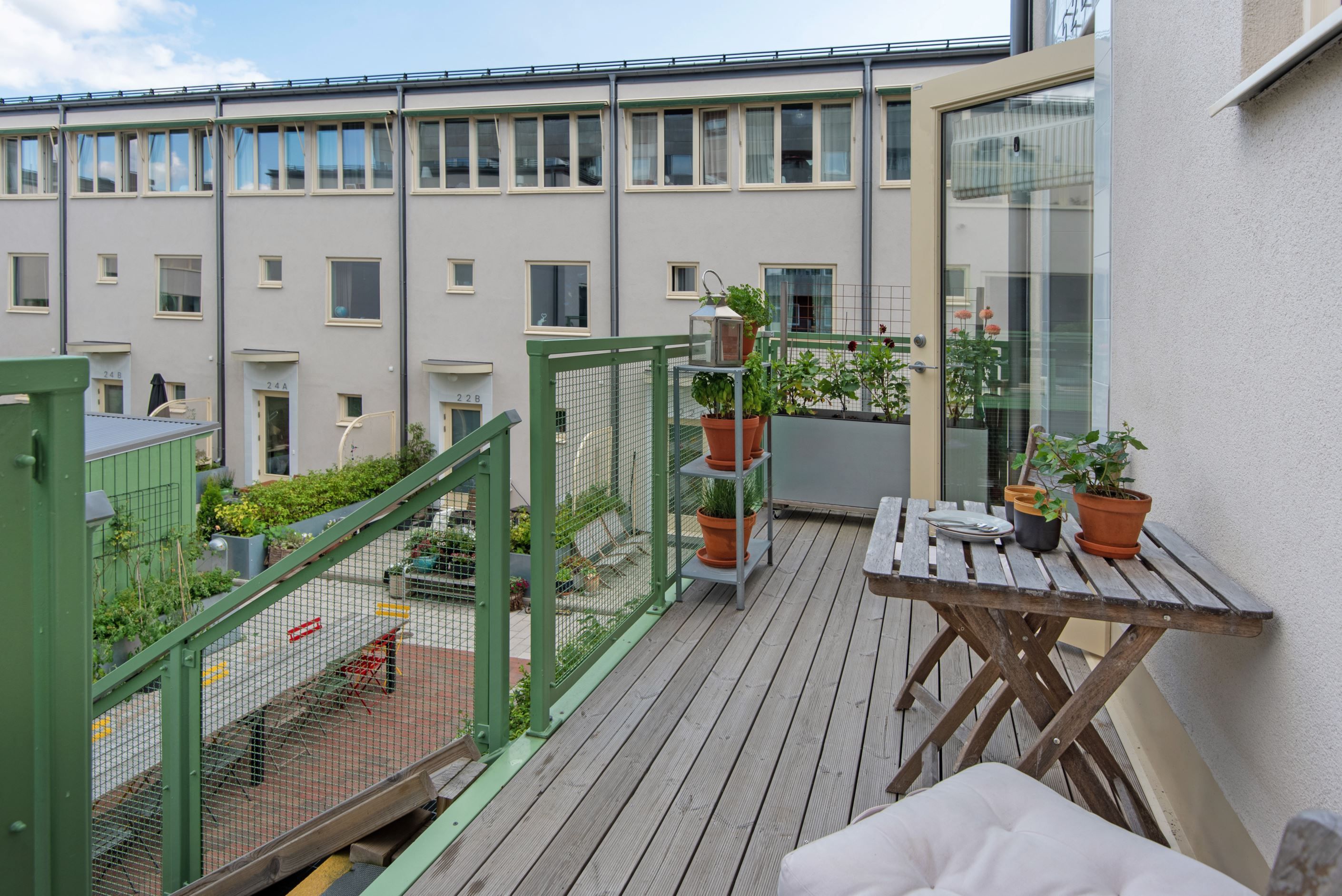 Balkong med morgonsol. Entrédörr av glas.