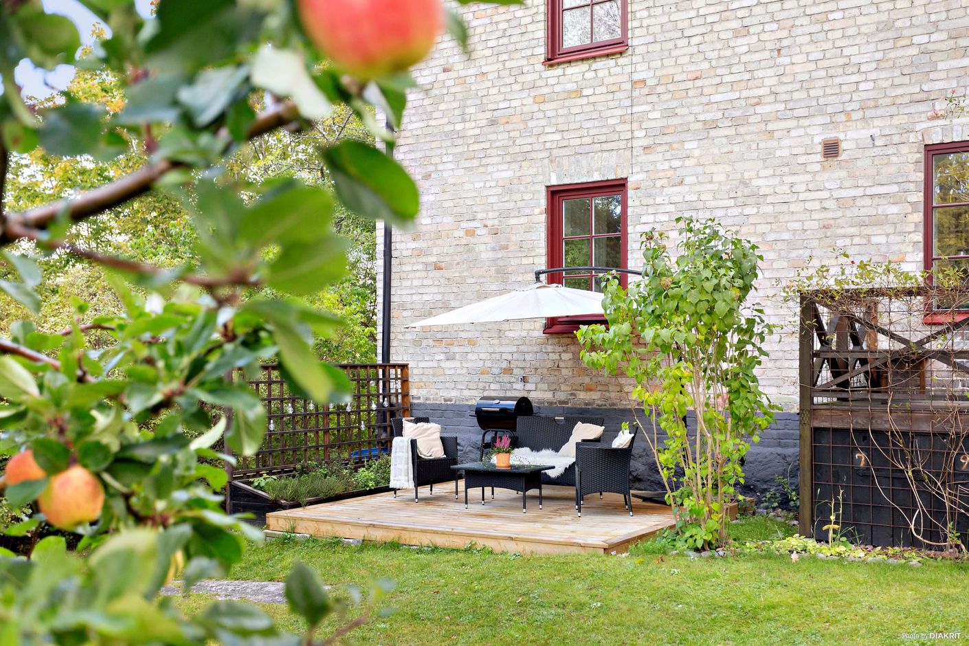 Härligt uppväxt trädgård med planteringar och gräsmatta