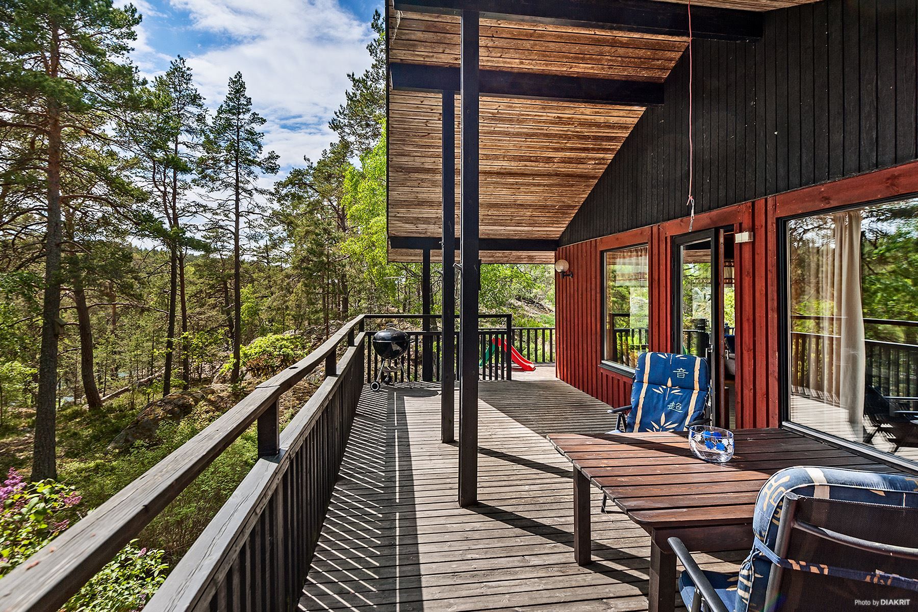 Stor altan som sträcker sig runt huset