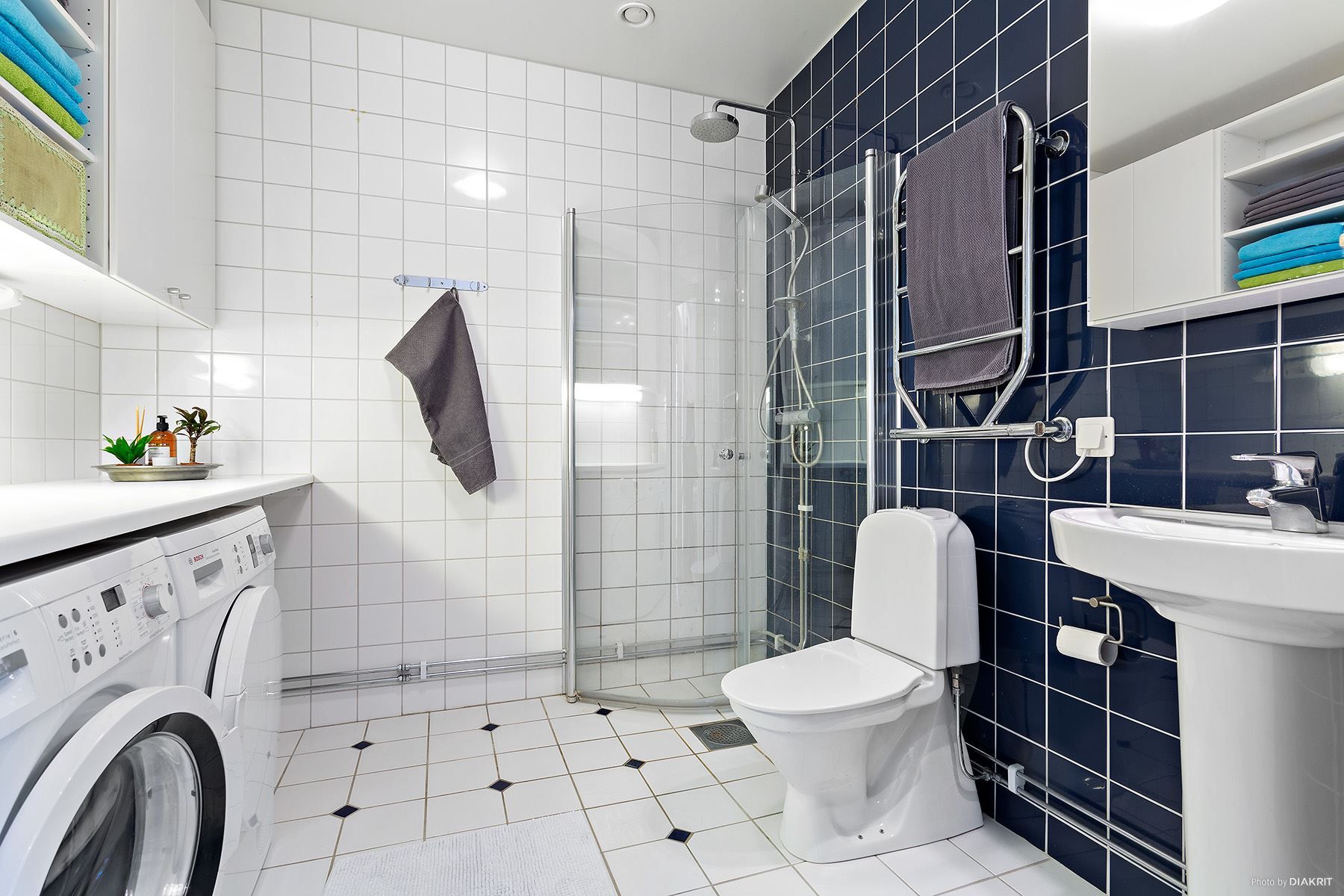 Stort och rymligt helkaklat badrum med tvättutrustning