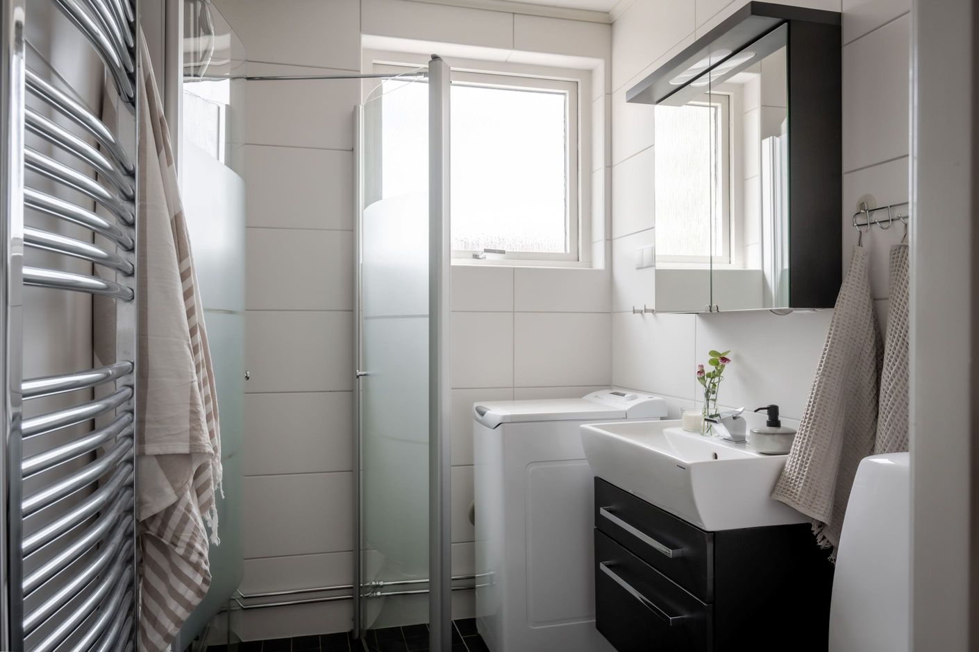 Smart planerat badrum med fint ljus och egen tvättmaskin