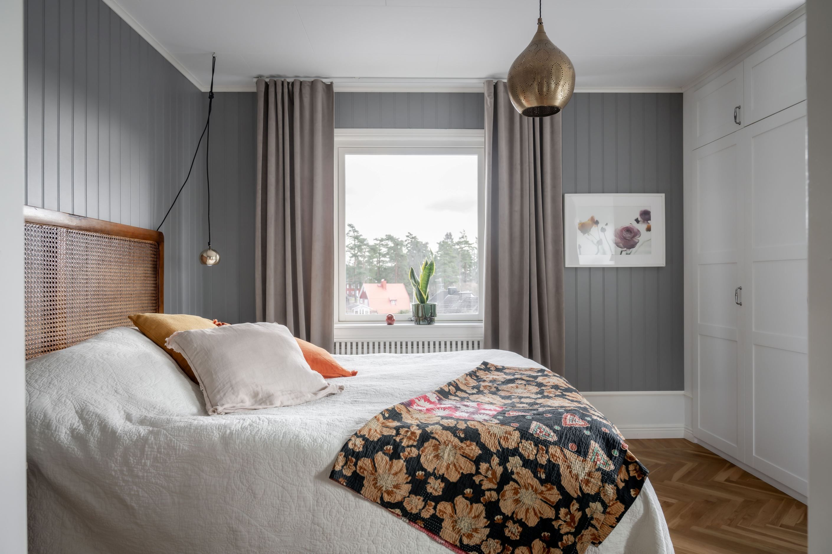 Master bedroom präglas av en genomtänkt design med fiskbensparkett och grå väggpanel.