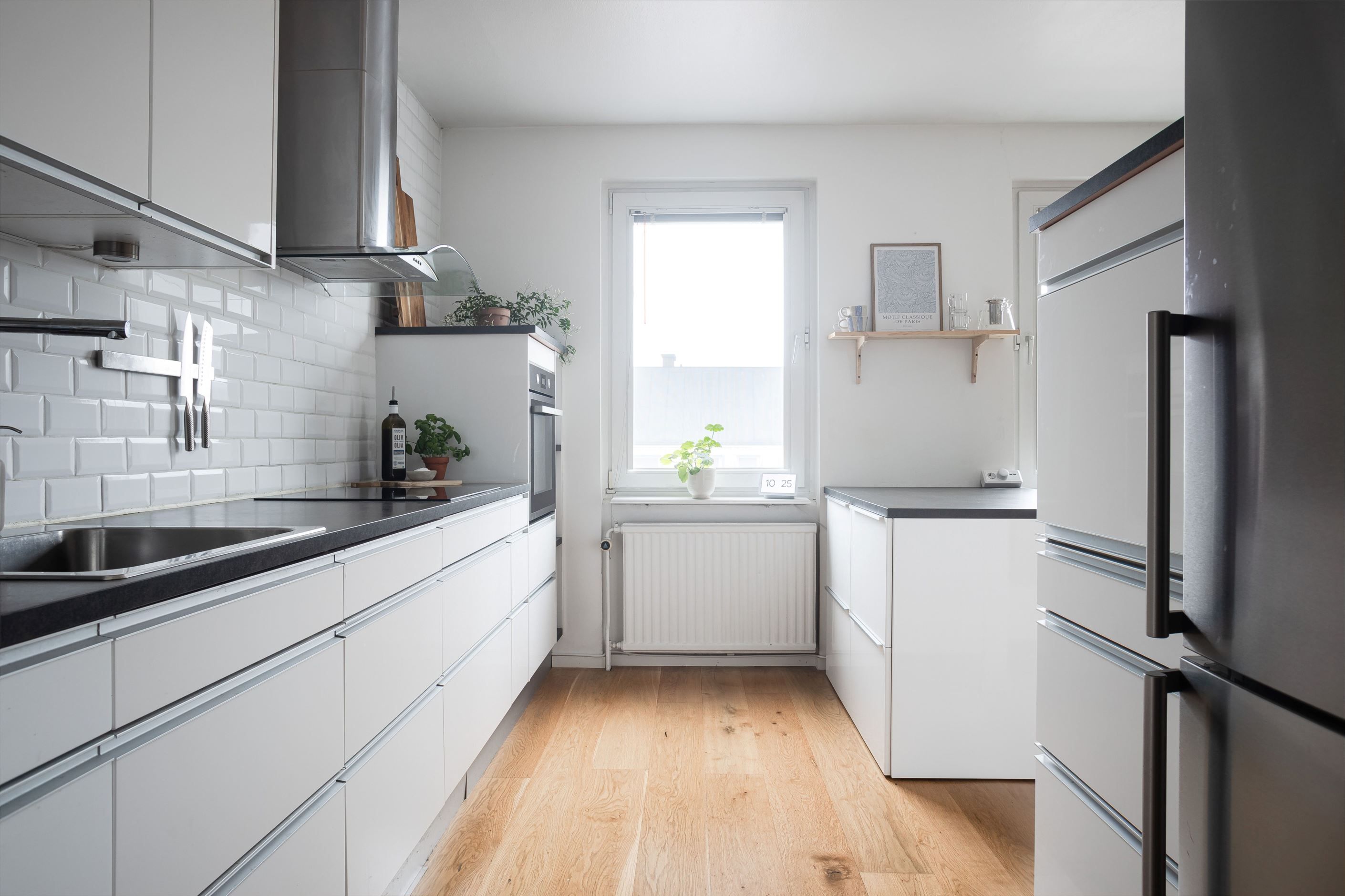 Stilrent kök med integrerad diskmaskin och trevlig köksö