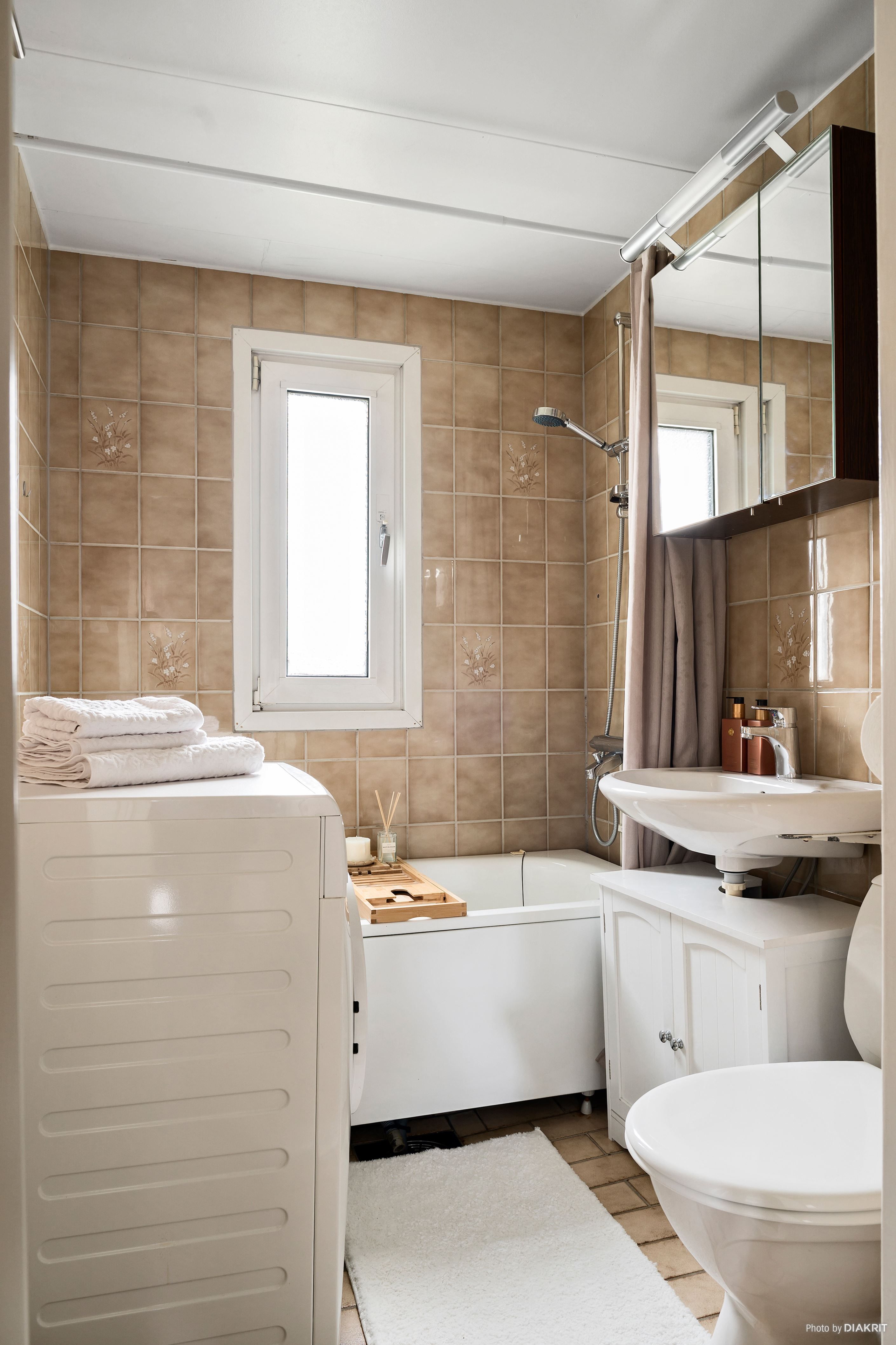 Helkaklat badrum med tvättmaskin