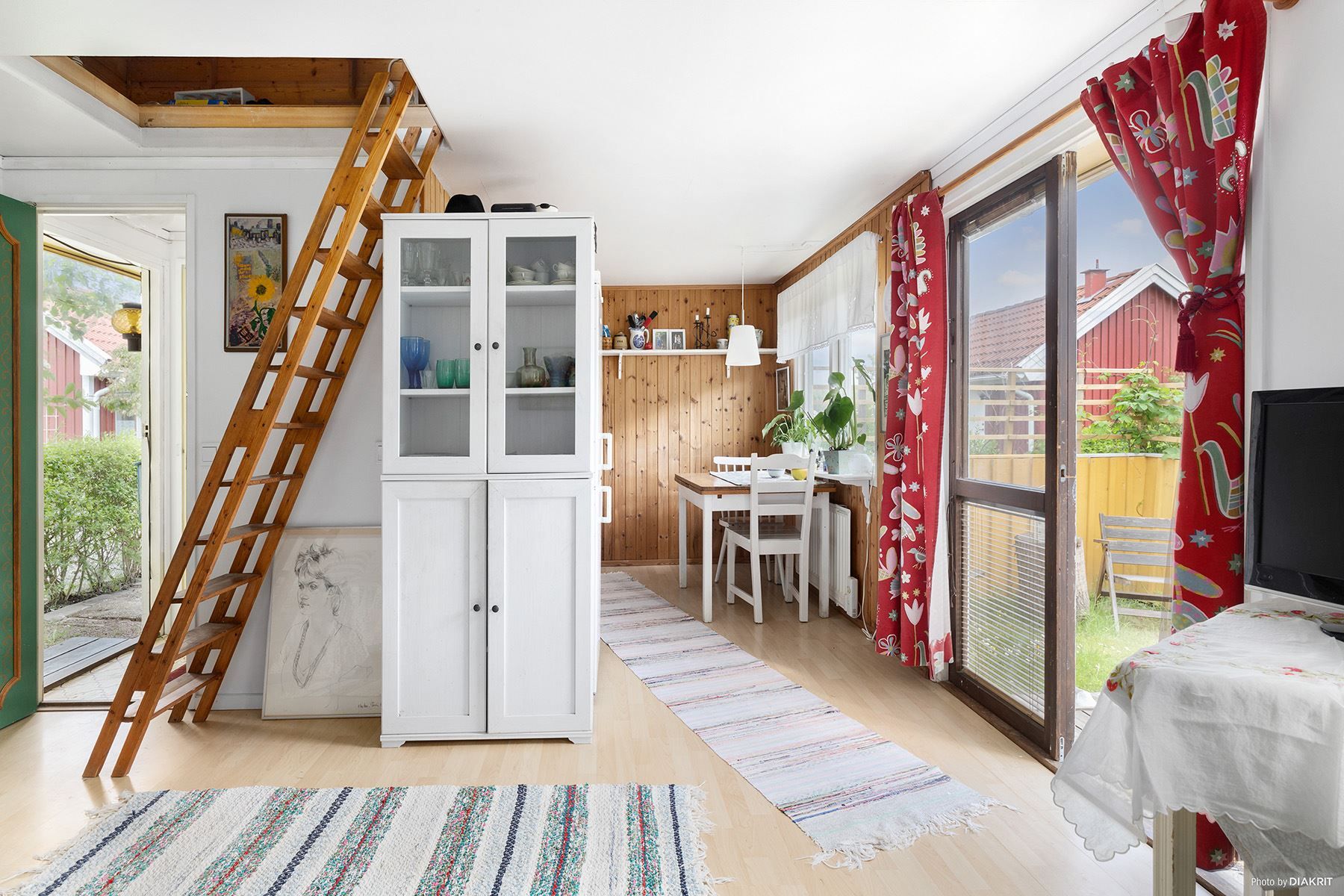 Ljust vardagsrum med plats för matbord och utgång till trädäck