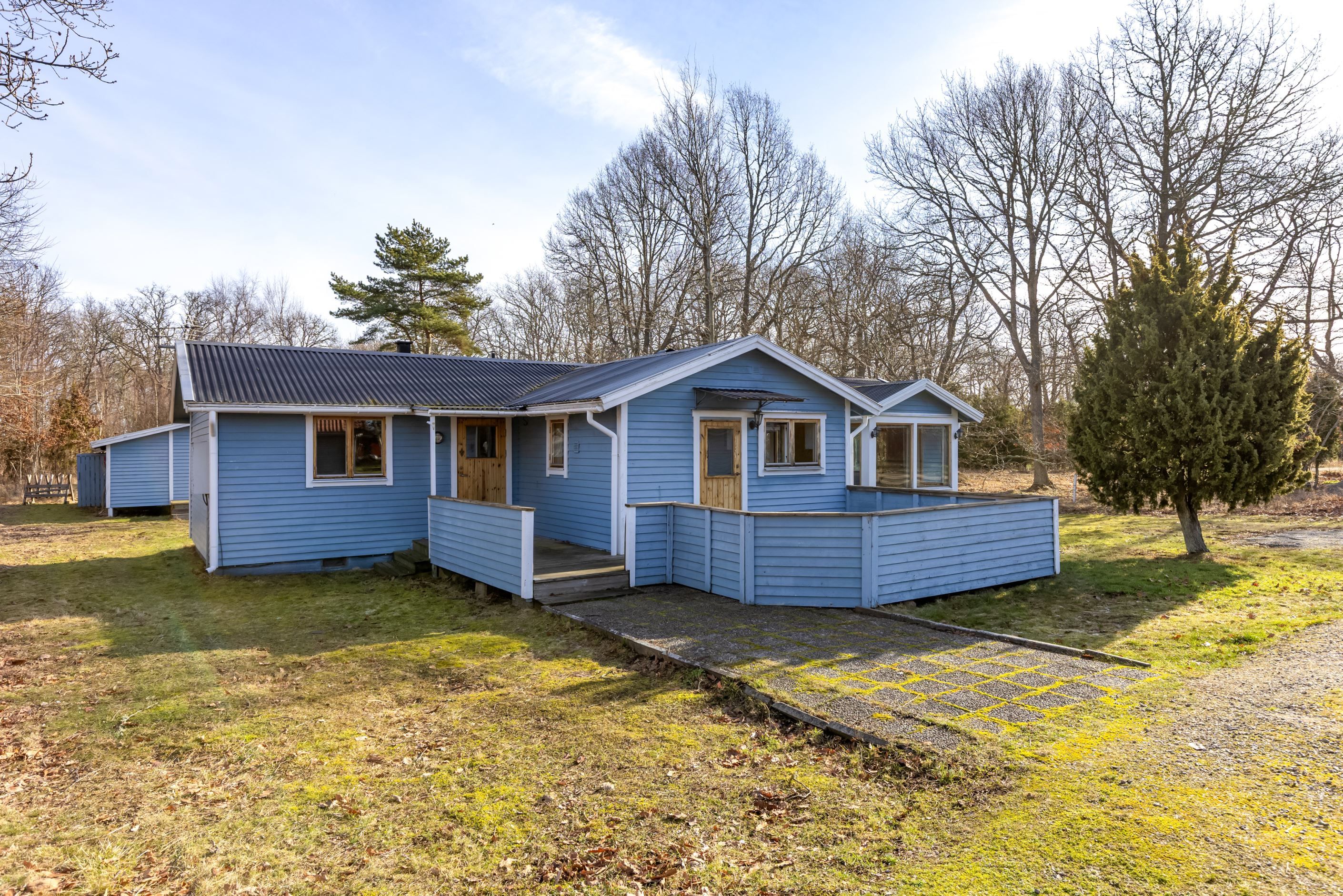 Entrésida. Huset har uteplats åt två väderstreck.