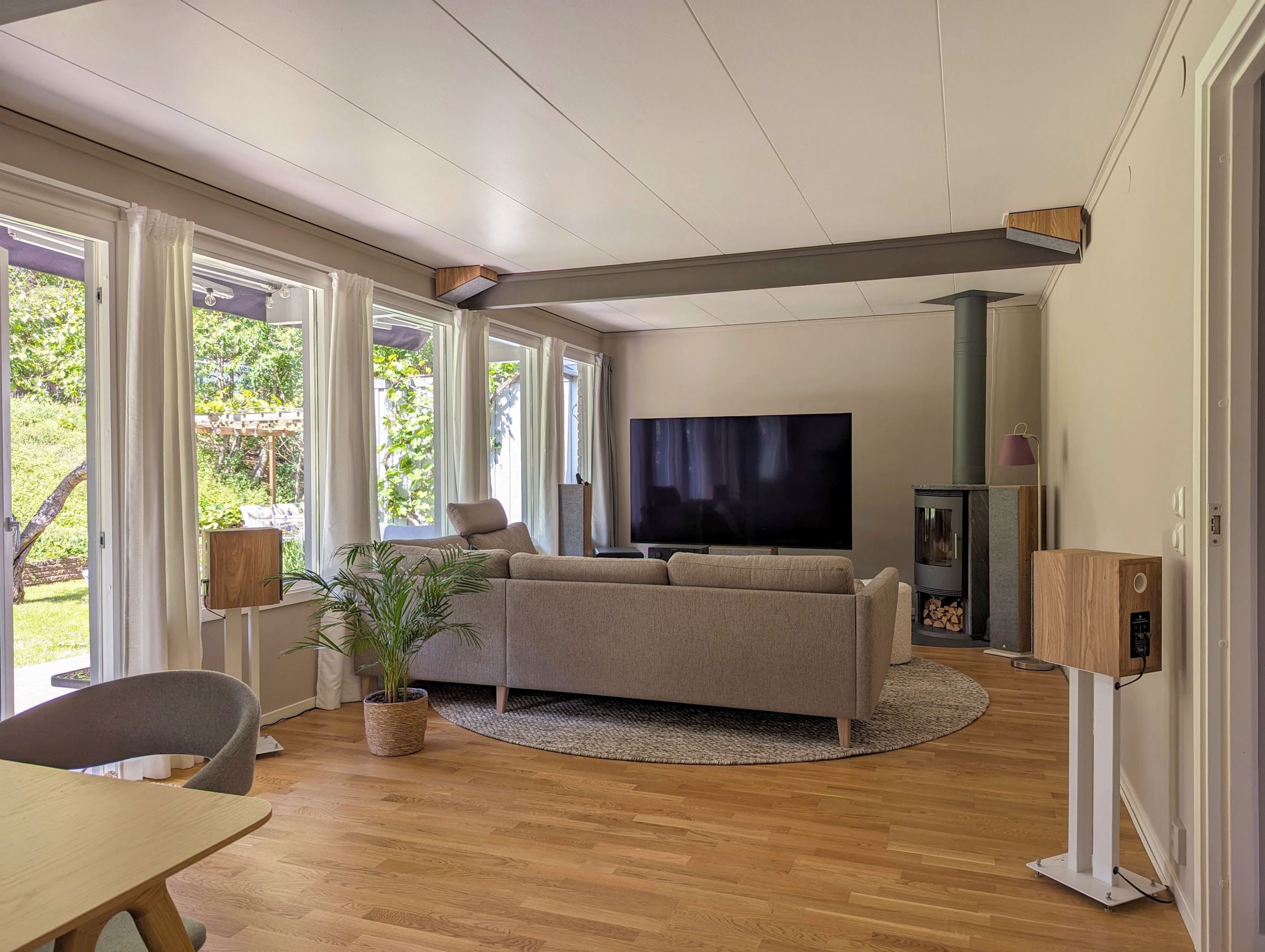 Vardagsrum med braskamin och utgång till trädäcksförsedd altan/uteplats på baksidan av huset