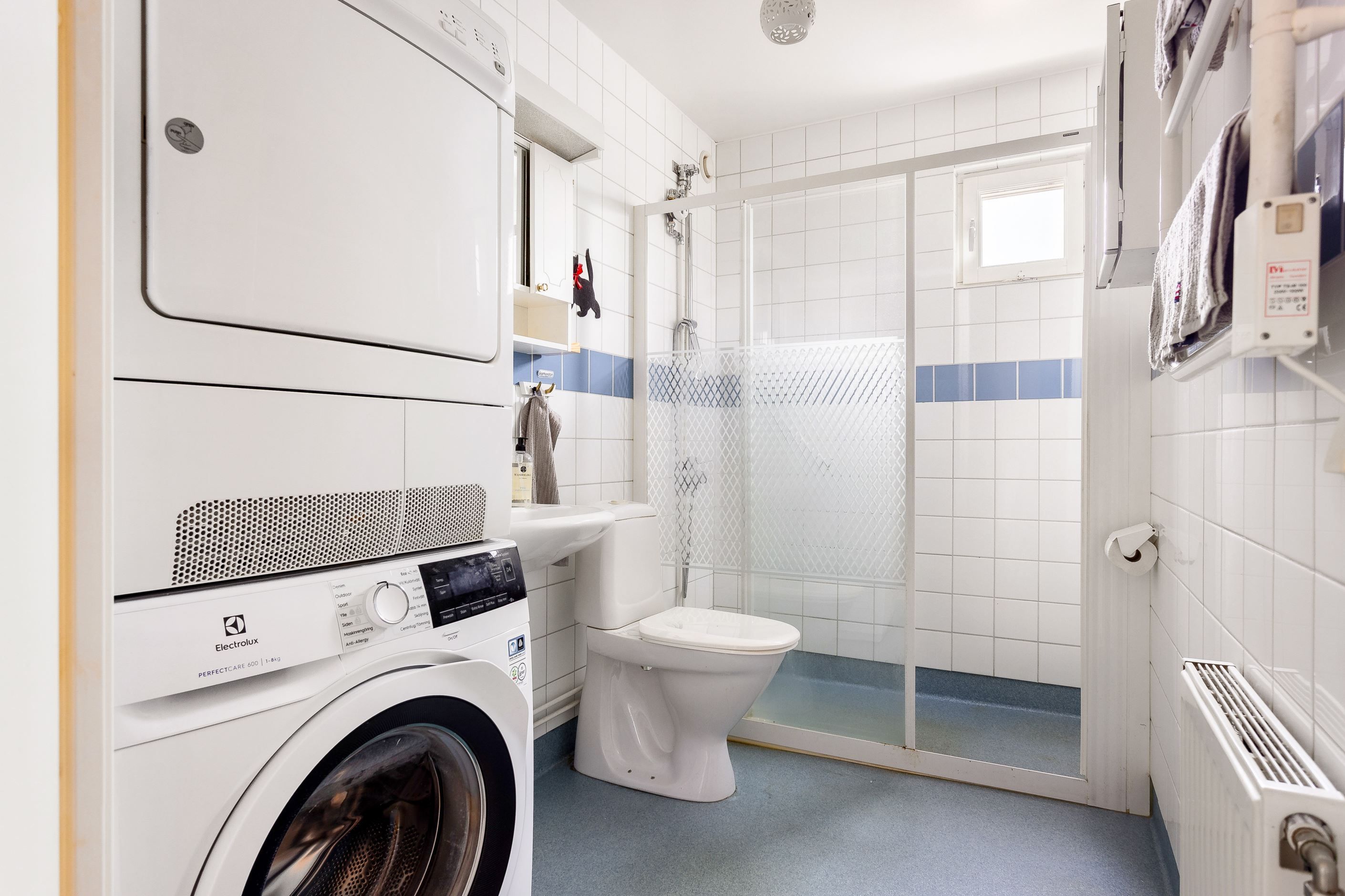 Stort badrum med tvättpelare.