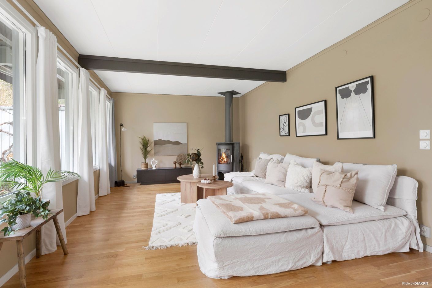 Vardagsrum med braskamin och med plats för såväl soffgrupp som matgrupp