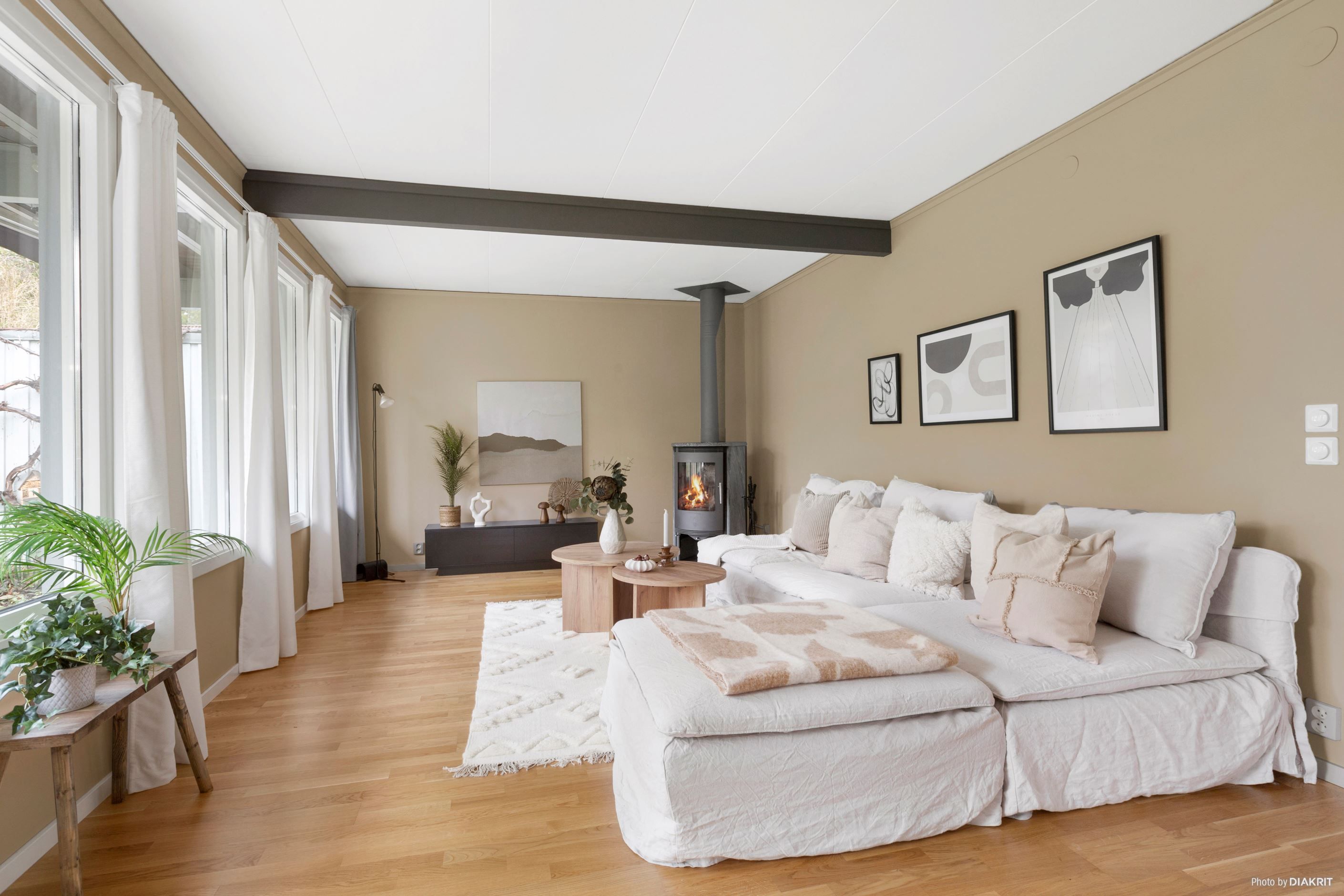 Vardagsrum med braskamin och med plats för såväl soffgrupp som matgrupp