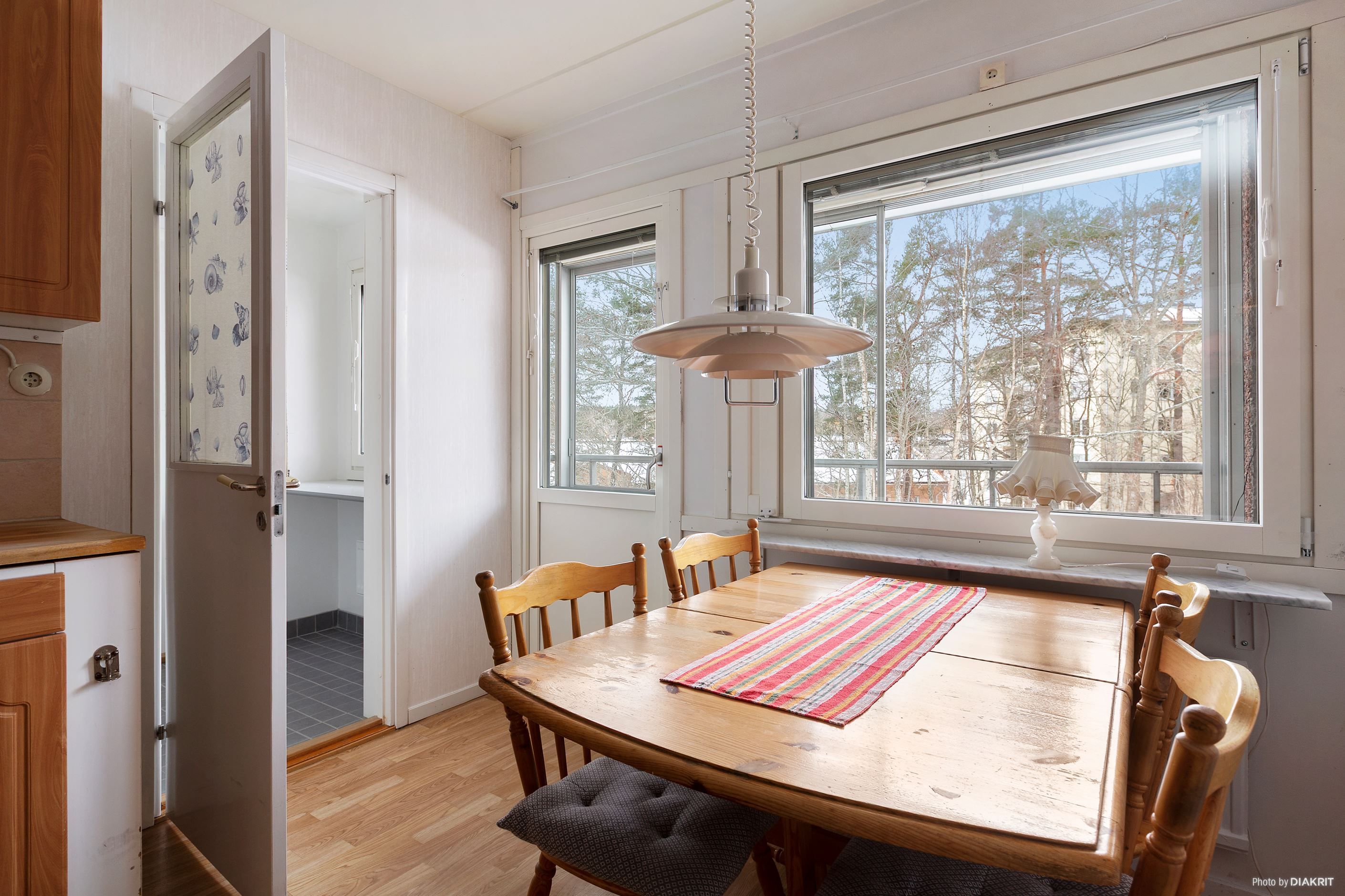 Rymligt kök med matplats med utgång till inglasad balkong