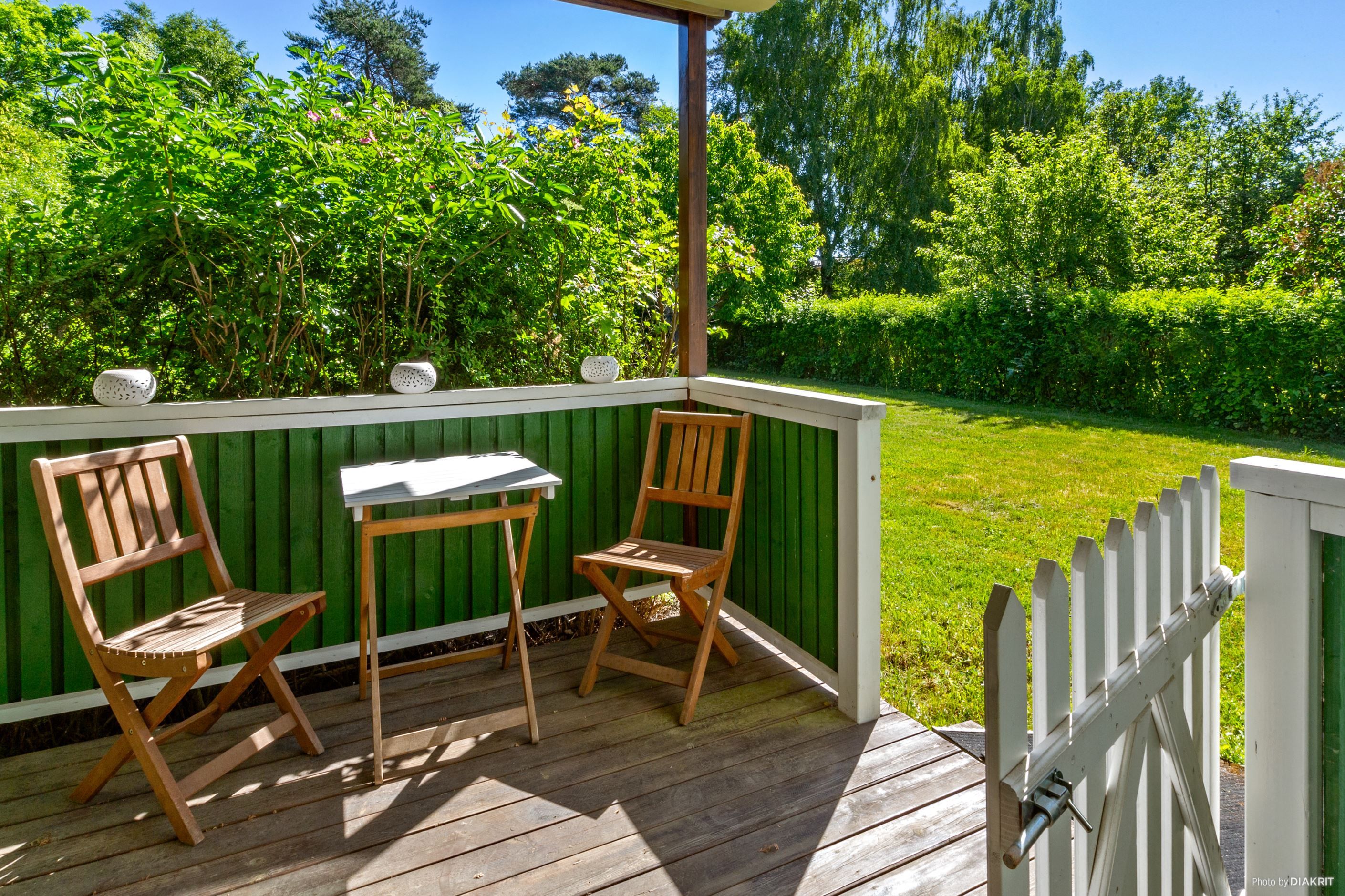 Trädäcksförsedd altan/uteplats på baksidan av huset, under tak och med utgång från köket
