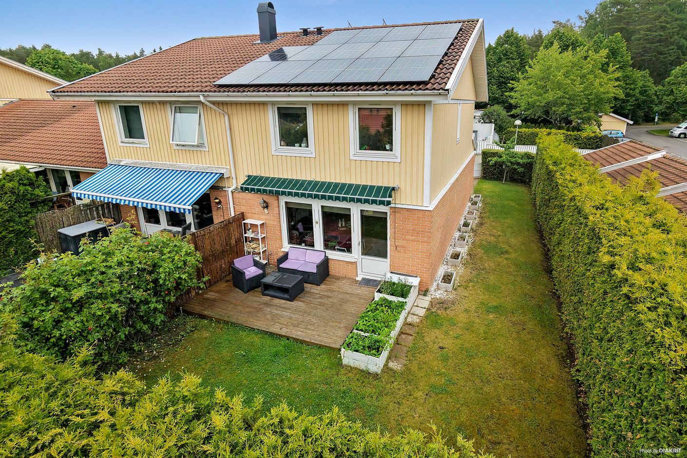 Fasadbild från baksidan av huset, med uteplats och solpaneler